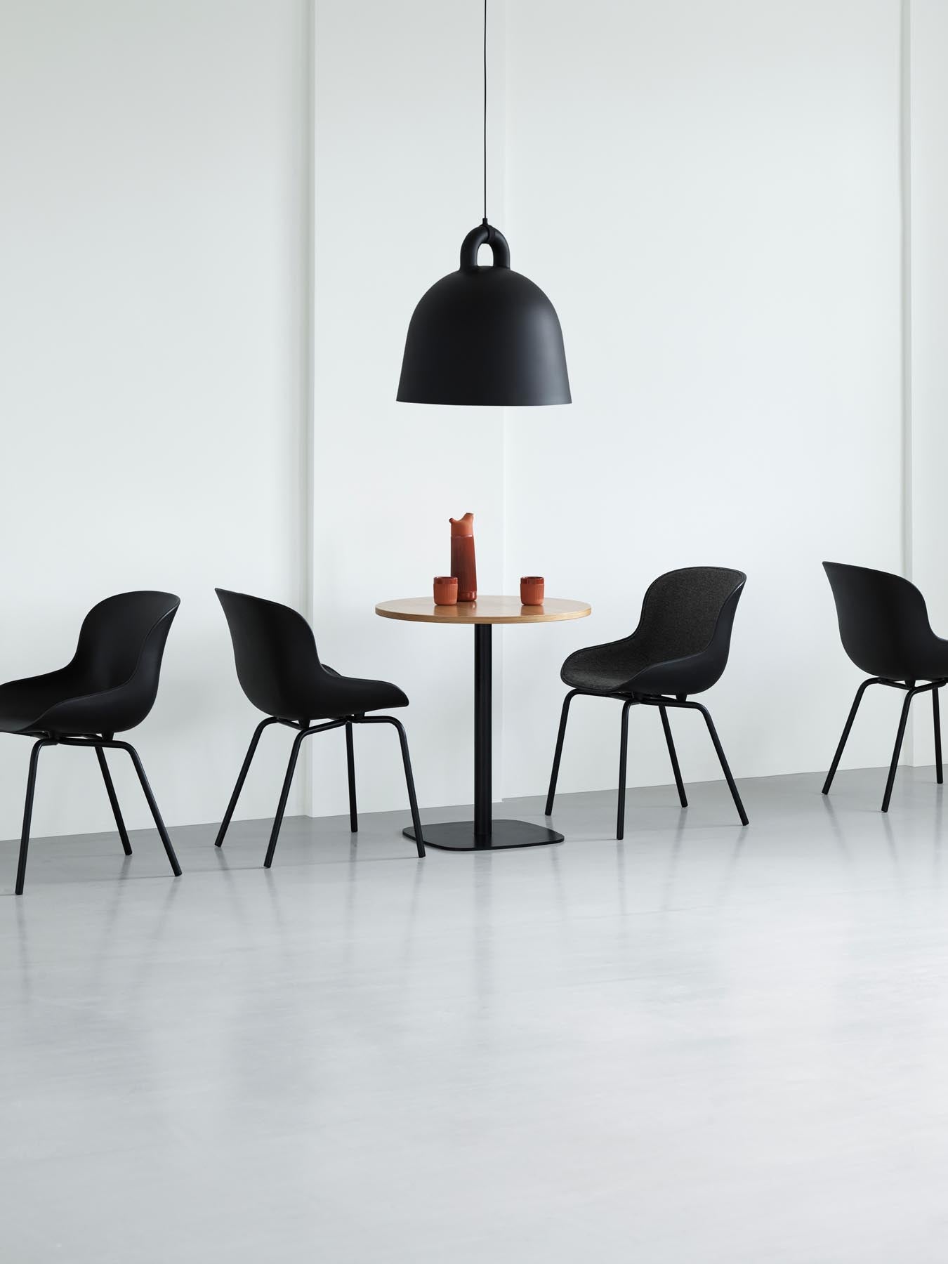Erleben Sie den Hyg Stuhl von Normann Copenhagen: Graues Frontpolster und elegantes Stahlgestell bieten skandinavische Gemütlichkeit und Stil.