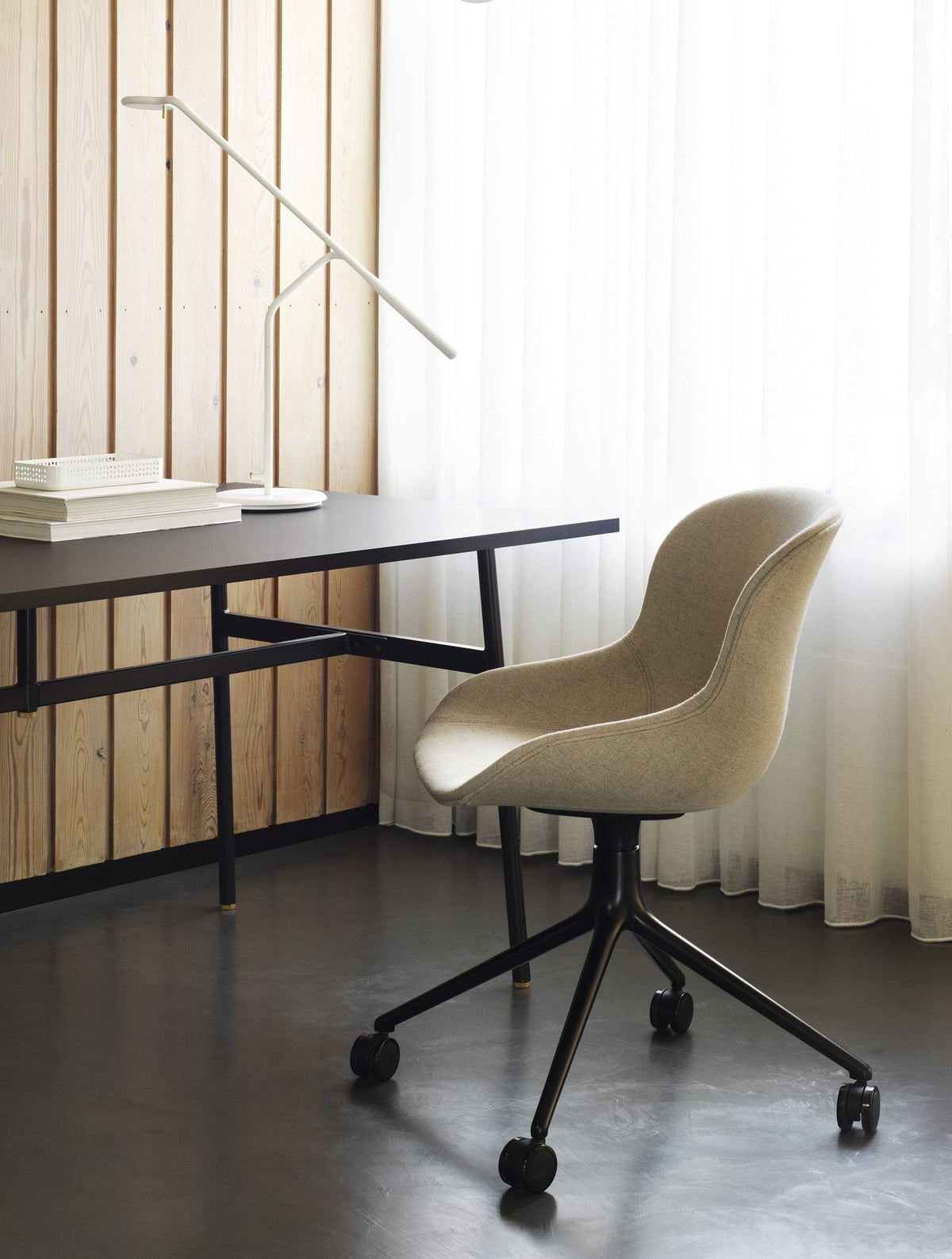 Drehsessel Hyg von Normann Copenhagen mit beiger Frontpolsterung, Schale aus Polypropylen und Drehgestell mit vier Rollen aus Aluminium.