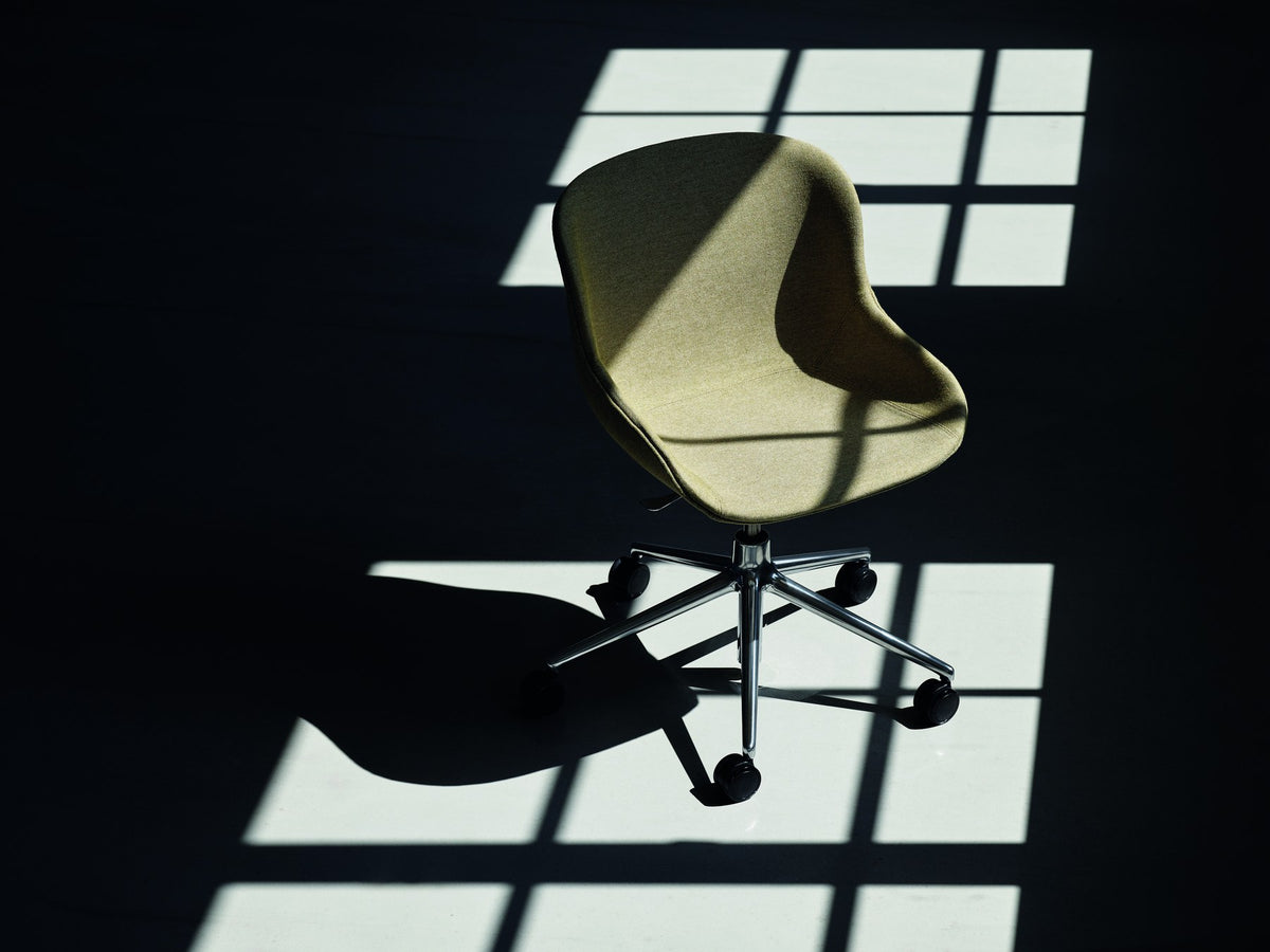 Grauer Hyg Comfort Drehsessel von Normann Copenhagen mit gepolsterter Schale, Aluminiumgestell und fünf Rollen auf drehbarem Fusskreuz.