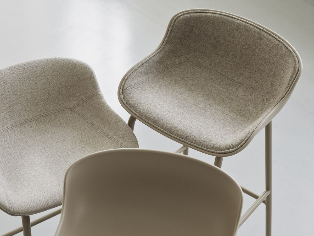 Hyg Barhocker von Normann Copenhagen mit gepolsterter Sitzschale aus Polypropylen, Frontpolster und Gestell aus grauem Stahl.