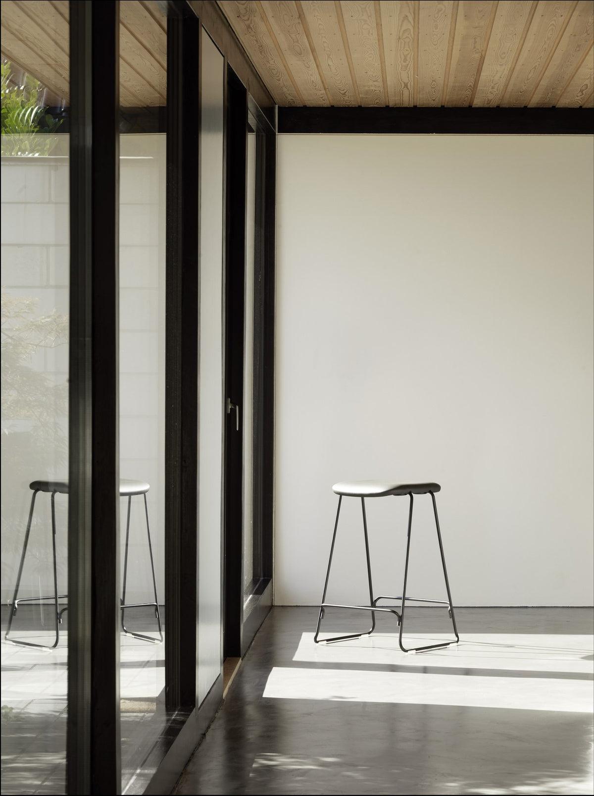 Just Barhocker von Normann Copenhagen, schwarz gepolstert, mit Schale aus Eichenfurnier und verchromtem Stahlgestell.