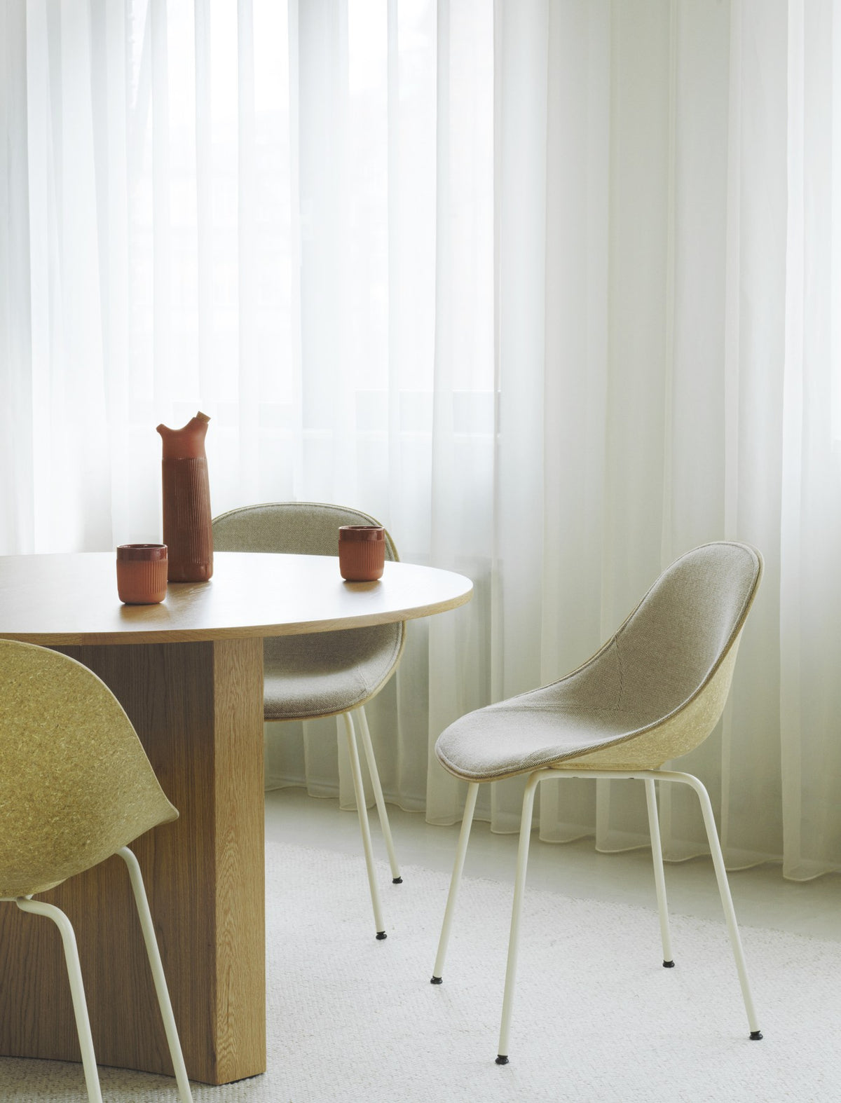 Stuhl Mat von Normann Copenhagen mit cremefarbener Sitzschale aus Hanffasern und Seegras, montiert auf vier lackierten Stahlbeinen.
