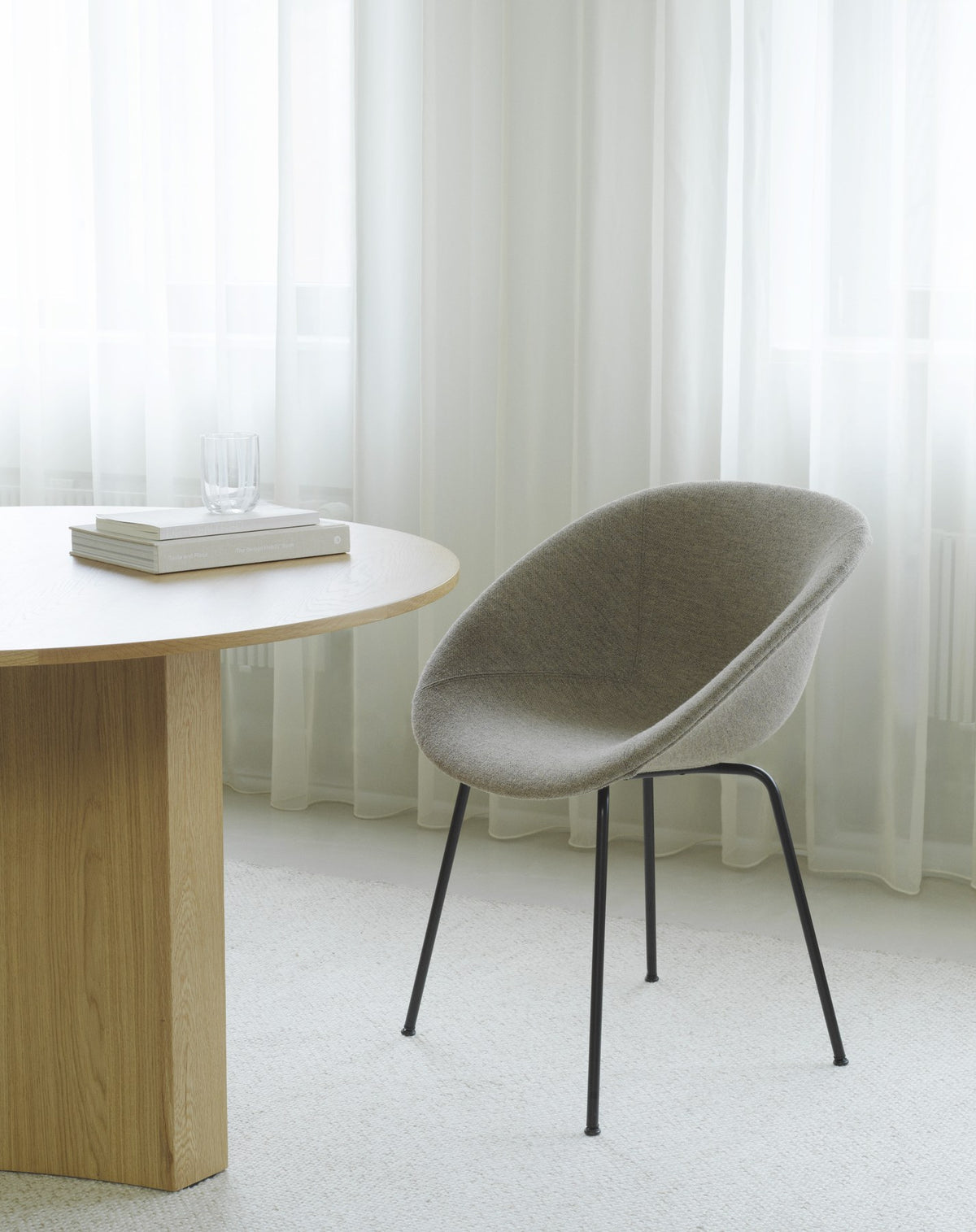 Barstuhl Mat von Normann Copenhagen mit Sitzschale aus Hanf- und Seetangfasern, Armlehnen und schwarzem pulverbeschichtetem Stahlgestell.