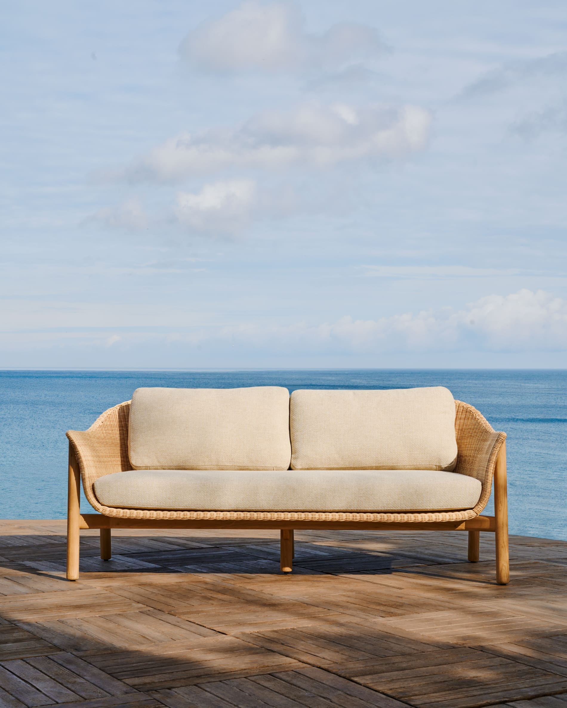 Elegantes 2-Sitzer-Sofa aus Teakholz und Rattan, ideal für drinnen und draussen, bietet Komfort und zeitlosen Stil.
