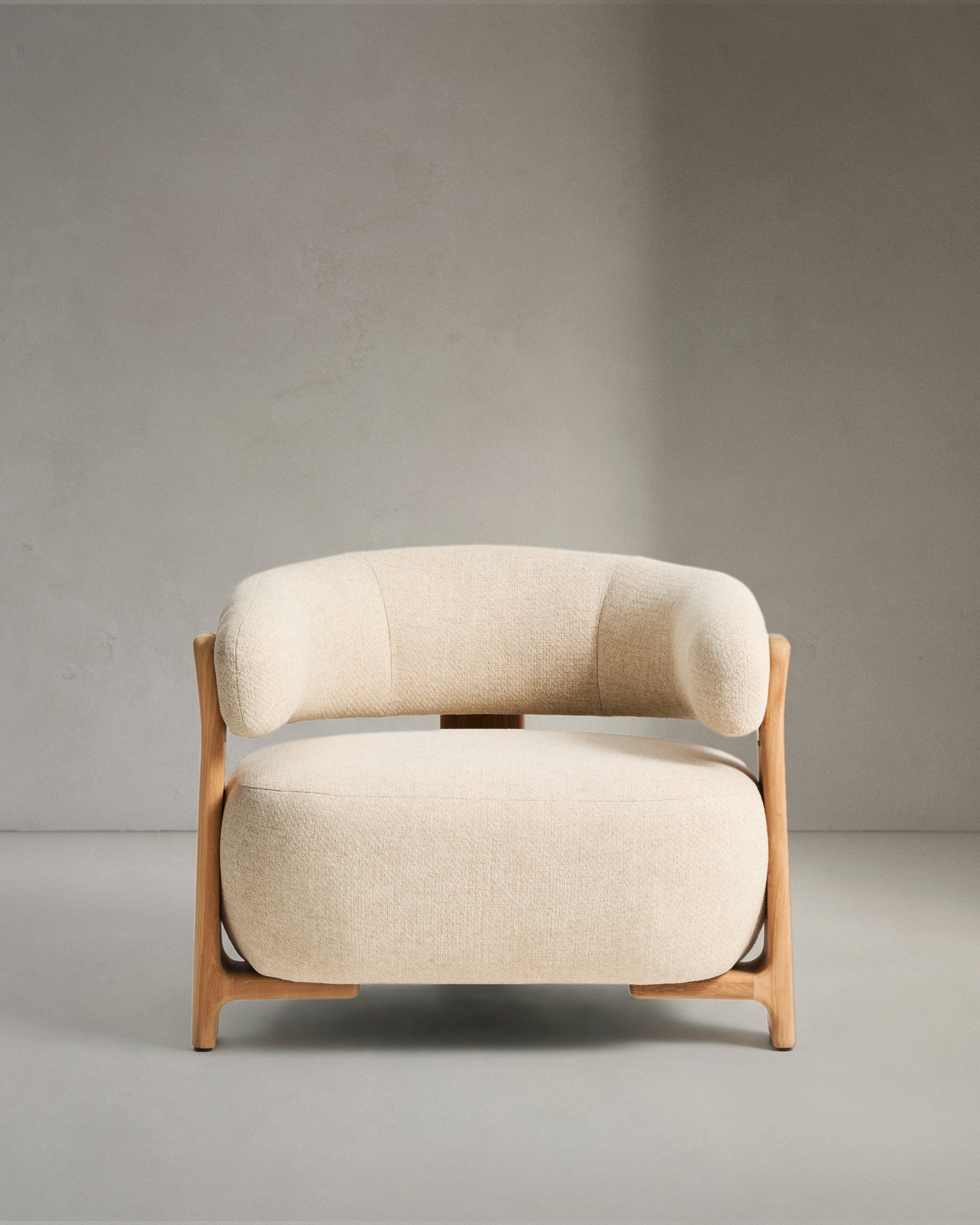 Eleganter beiger Outdoor-Sessel Granit mit stabilen Teakholzbeinen, perfekt für gemütliche Stunden im Freien, von Kave Home.