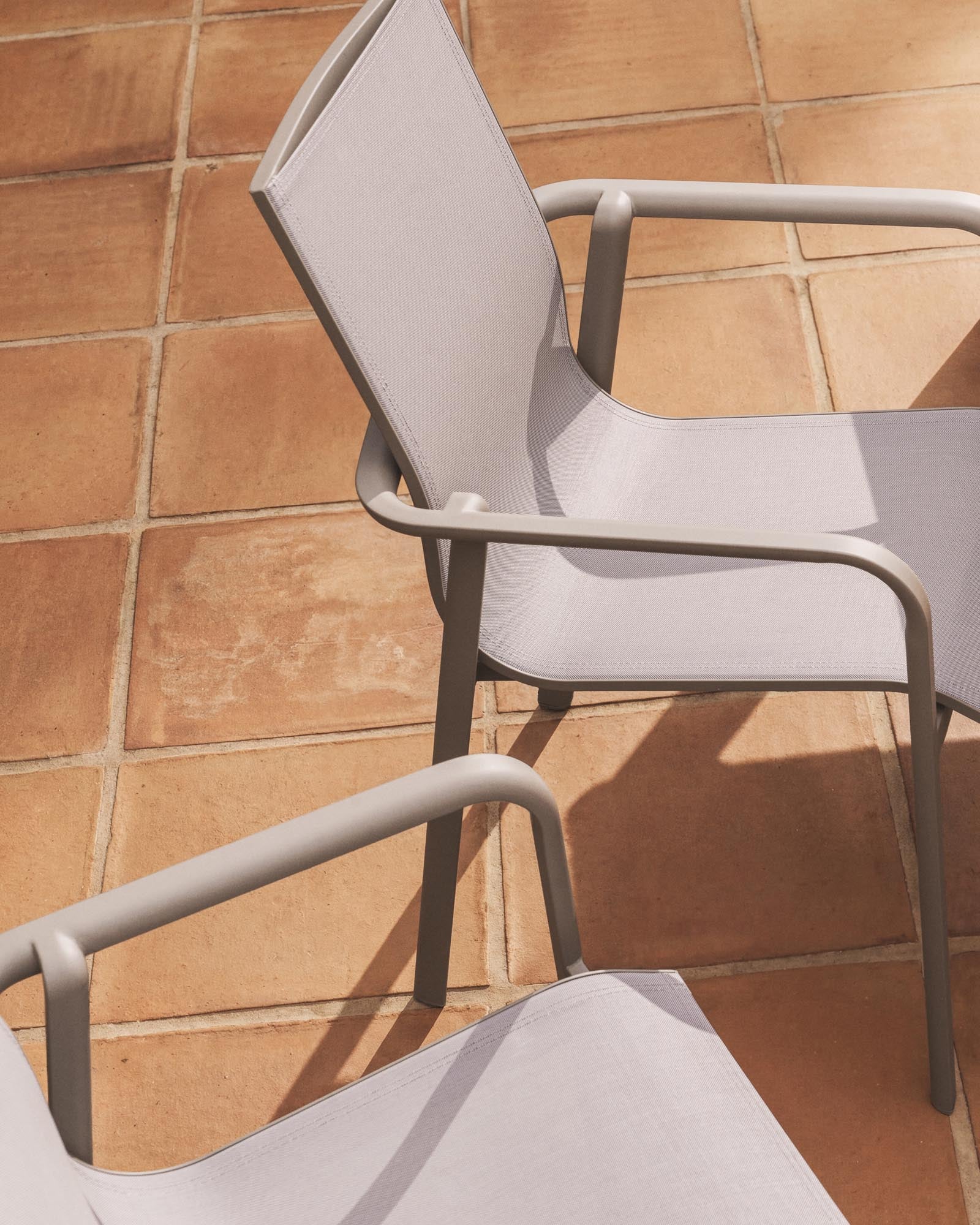 Stapelbarer Outdoor-Stuhl Canea in Taupe, aus beigem Texteline und Aluminium, perfekt für entspannte Stunden im Garten oder auf der Terrasse.