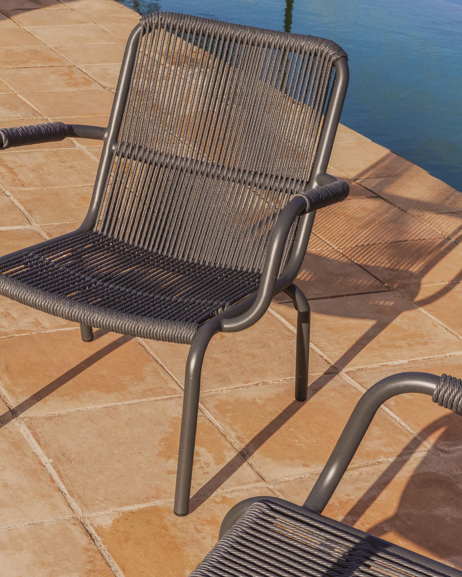 Eleganter stapelbarer Sessel Salis aus graphitgrauem Aluminium und dunkelgrauem Synthetikseil, ideal für stilvolle Outdoor-Bereiche.