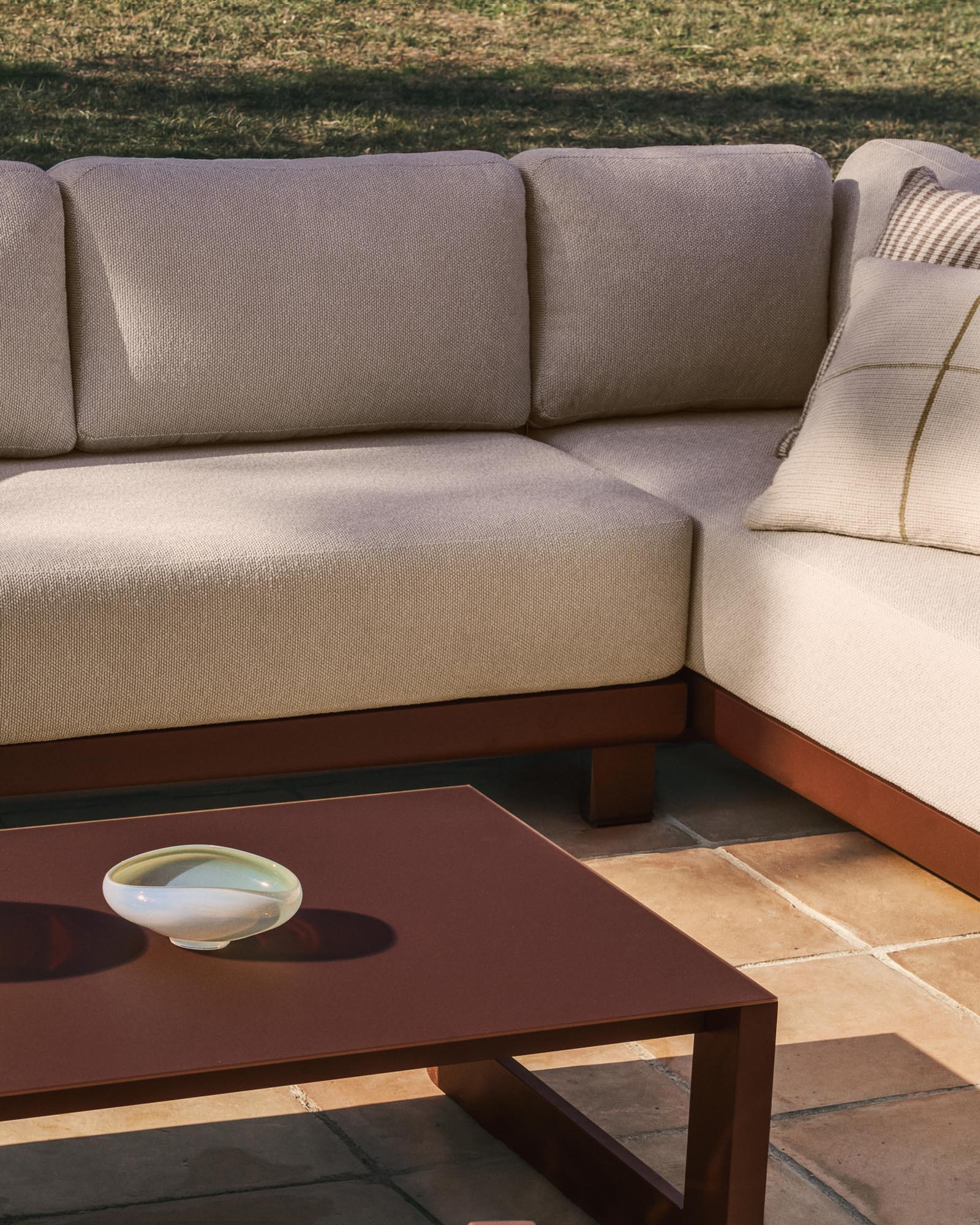 Elegantes Loungeset Nerano mit 5-Sitzer-Ecksofa, Sessel und stilvollem Couchtisch aus robustem Glas und braunem Aluminium.