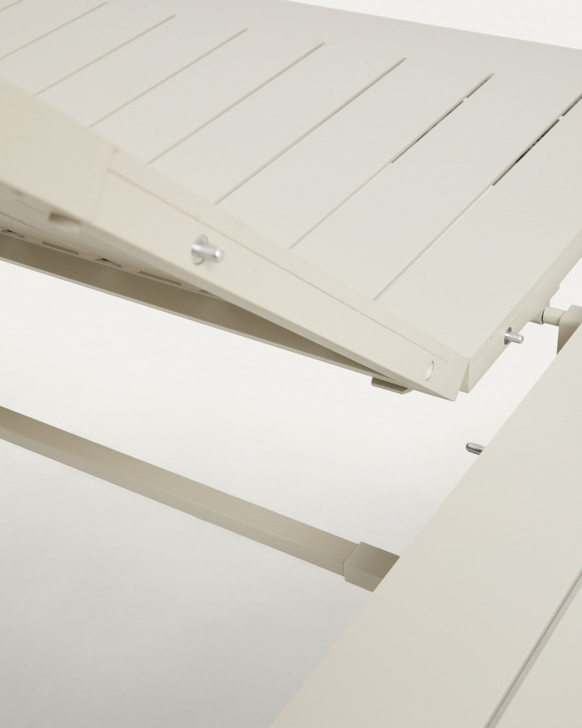 Ausziehtisch aus Aluminium mit Holzoptik-Beinen in Beige und sechs stapelbare Aluminiumstühle in Ecru mit beigem Sitzkissen.