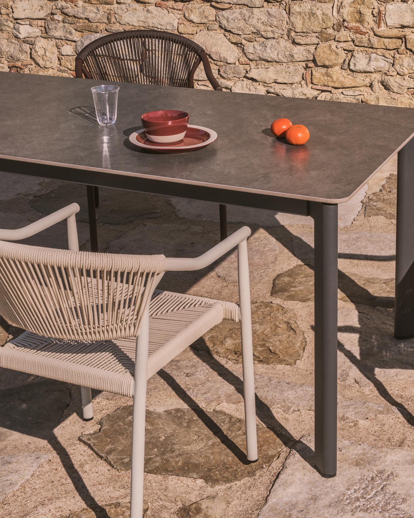 Tischset Anafi aus gesintertem Stein und graphitgrauem Aluminium sowie 4 Stühle Livadia aus graphitgrauem Aluminium, 180 x 90 cm in Graphit präsentiert im Onlineshop von KAQTU Design AG. Loungeset ist von Kave Home