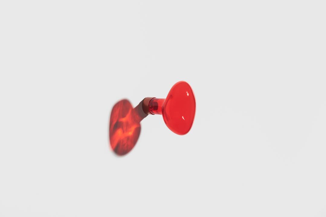 Kleiderhaken Bubble in Limette aus mundgeblasenem, lackiertem Glas mit rundem Blasen-Design und mattem Stahl-Befestigungssystem an weisser Wand.