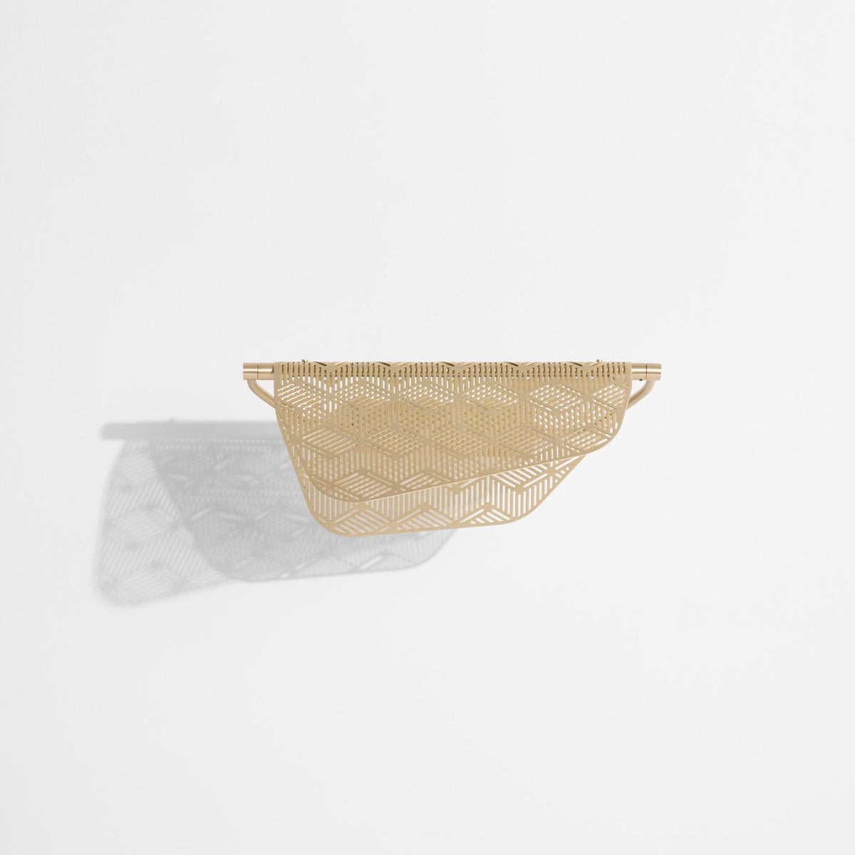 Wandlampe Mediterranea von Petite Friture aus gebürstetem Messing mit spitzenartiger, durchbrochener Struktur an heller Wand montiert.