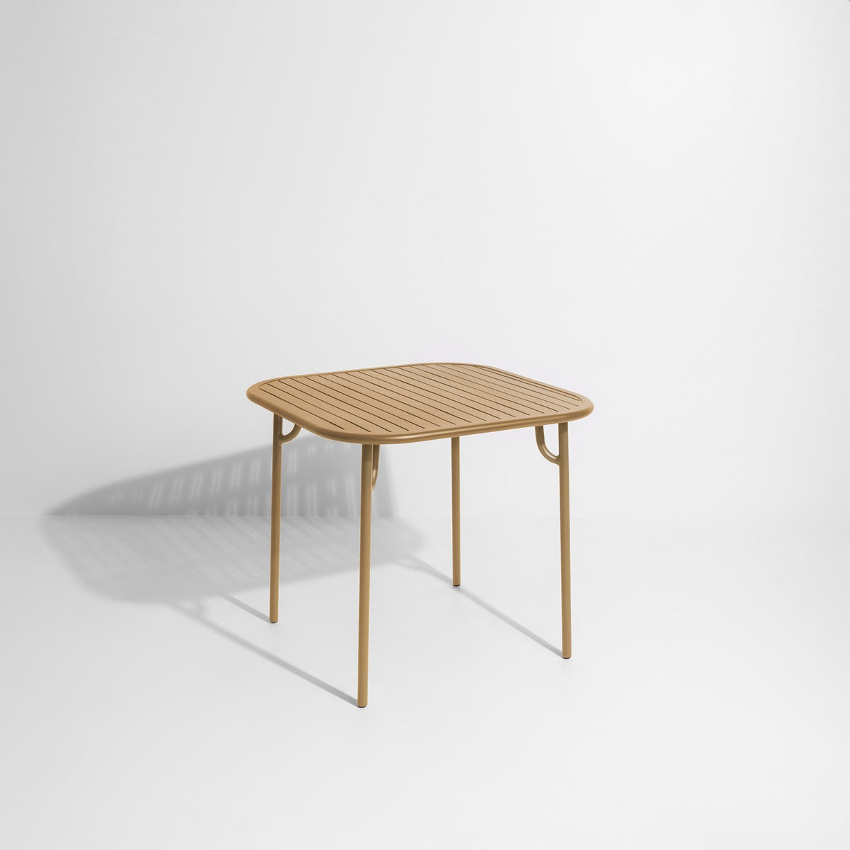 Week-End Tisch Small von Petite Friture in Gold: ovale Tischplatte mit horizontalen Lamellen-Streifen, Gestell aus mattiertem Aluminium.