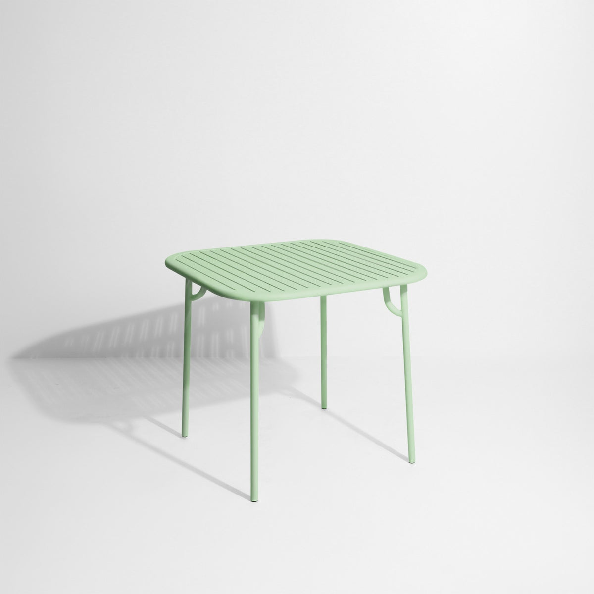 Week-End Tisch Small von Petite Friture in Gold: ovale Tischplatte mit horizontalen Lamellen-Streifen, Gestell aus mattiertem Aluminium.