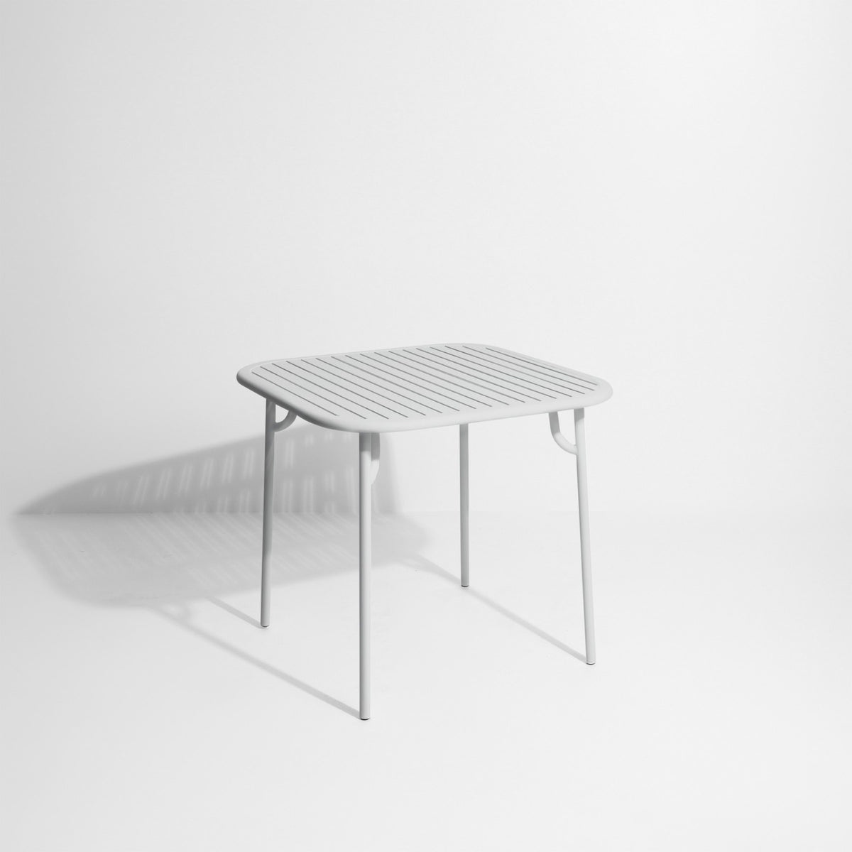 Week-End Tisch Small von Petite Friture in Gold: ovale Tischplatte mit horizontalen Lamellen-Streifen, Gestell aus mattiertem Aluminium.