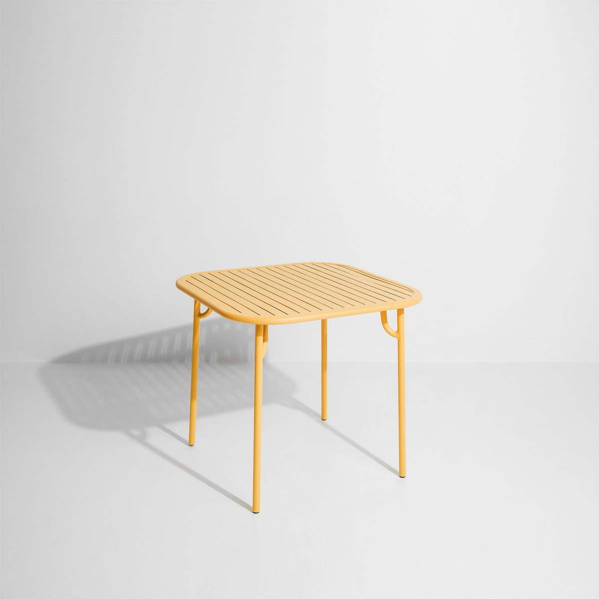 Week-End Tisch Small von Petite Friture in Gold: ovale Tischplatte mit horizontalen Lamellen-Streifen, Gestell aus mattiertem Aluminium.
