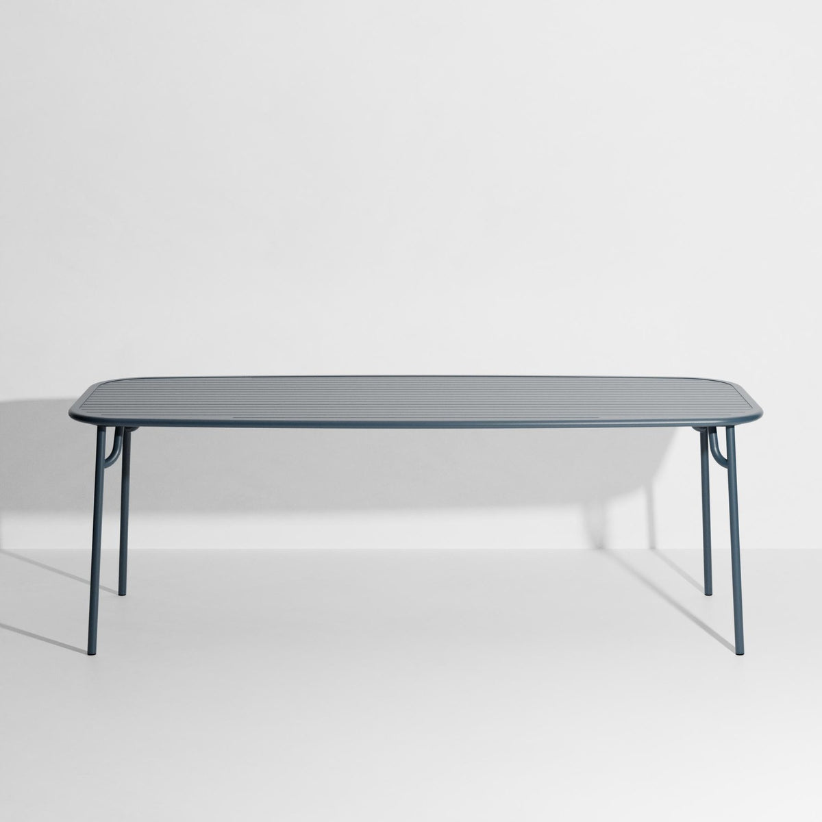Week-End Tisch Large von Petite Friture in Pigeon Blue: ovaler Gartentisch aus Aluminium mit gerahmten, streifenartigen Lamellen.