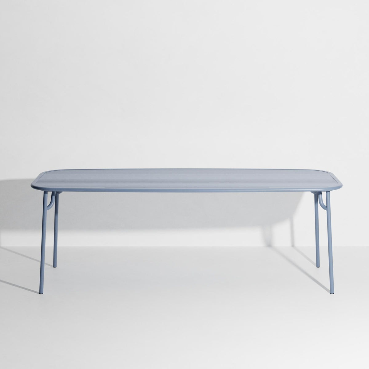 Week-End Tisch Large von Petite Friture in Pigeon Blue: ovaler Gartentisch aus Aluminium mit gerahmten, streifenartigen Lamellen.