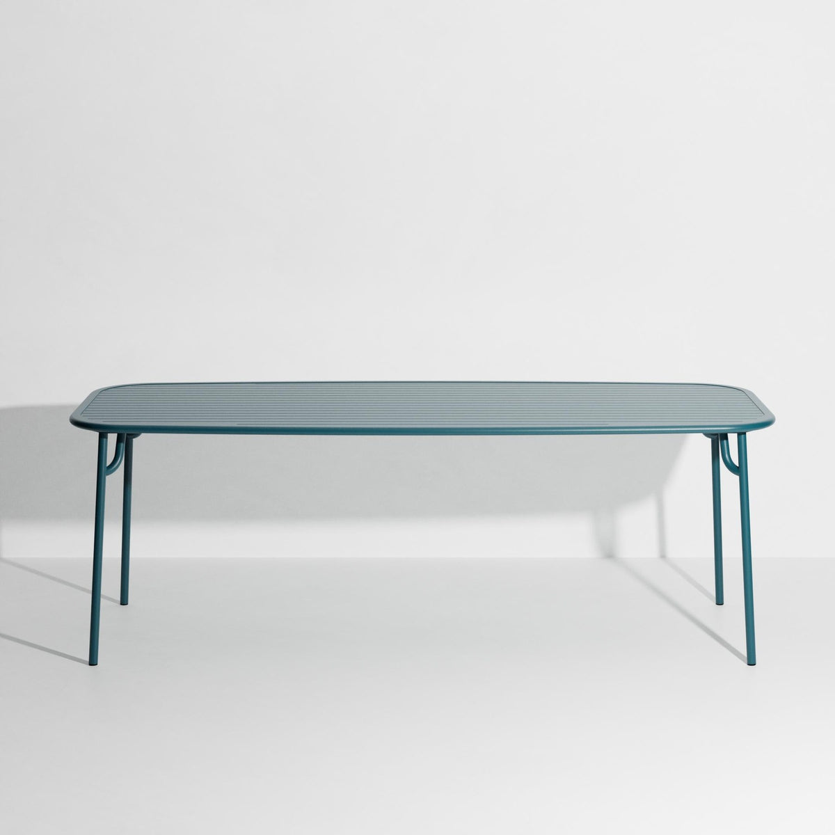 Week-End Tisch Large von Petite Friture in Pigeon Blue: ovaler Gartentisch aus Aluminium mit gerahmten, streifenartigen Lamellen.