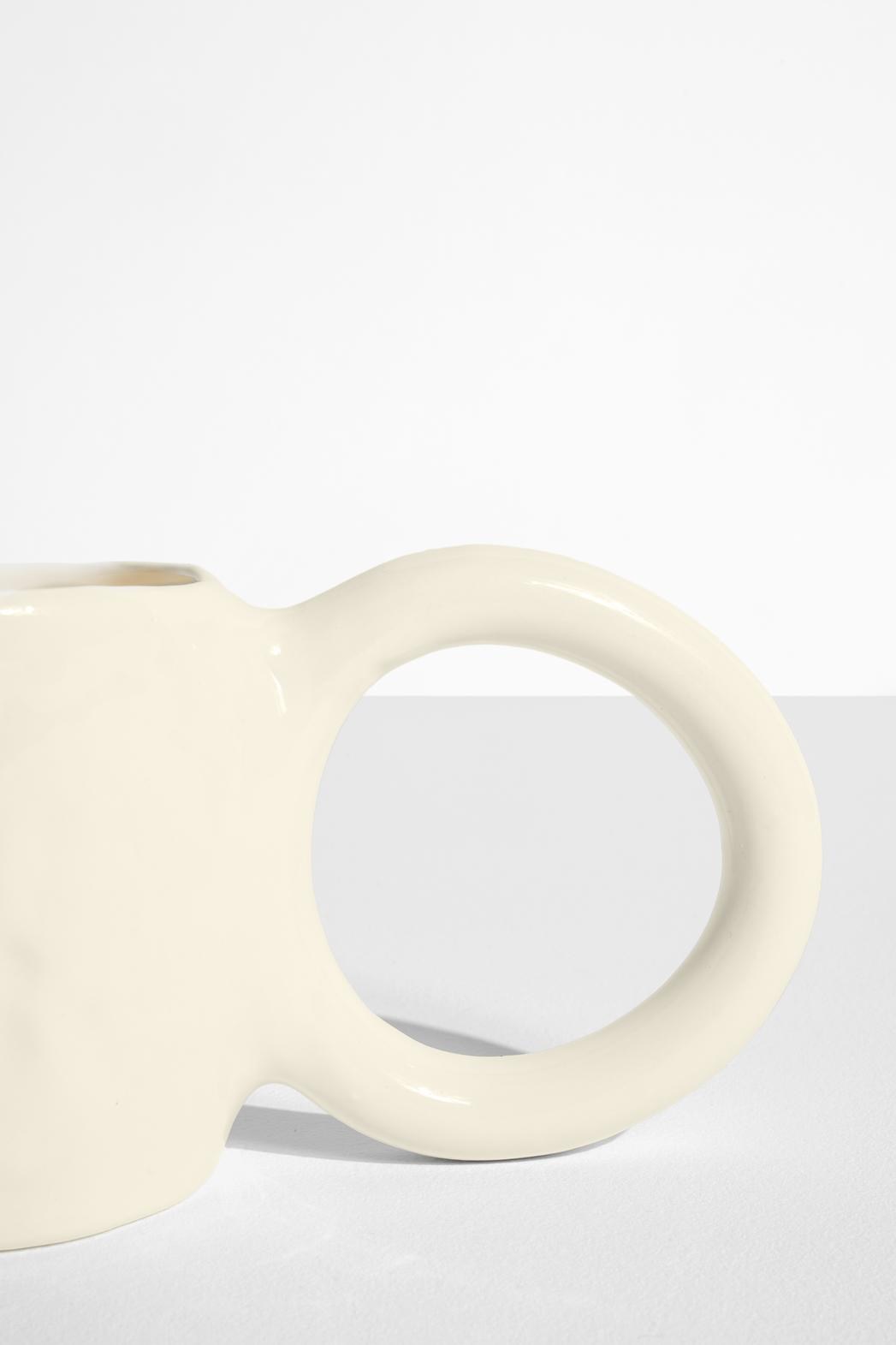 Keramiktasse Donut in Pistazie mit glasierter Oberfläche und donutförmigem Henkel, mittlere Grösse, handwerklicher Look, auf hellem Hintergrund.