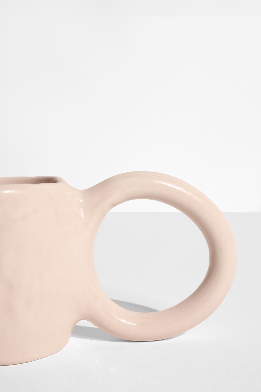 Keramiktasse Donut in Pistazie mit glasierter Oberfläche und donutförmigem Henkel, mittlere Grösse, handwerklicher Look, auf hellem Hintergrund.