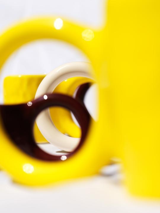 Keramiktasse Donut in Pistazie mit glasierter Oberfläche und donutförmigem Henkel, mittlere Grösse, handwerklicher Look, auf hellem Hintergrund.