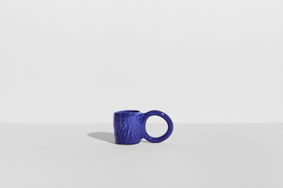 Keramiktasse Donut in Pistazie mit glasierter Oberfläche und donutförmigem Henkel, mittlere Grösse, handwerklicher Look, auf hellem Hintergrund.