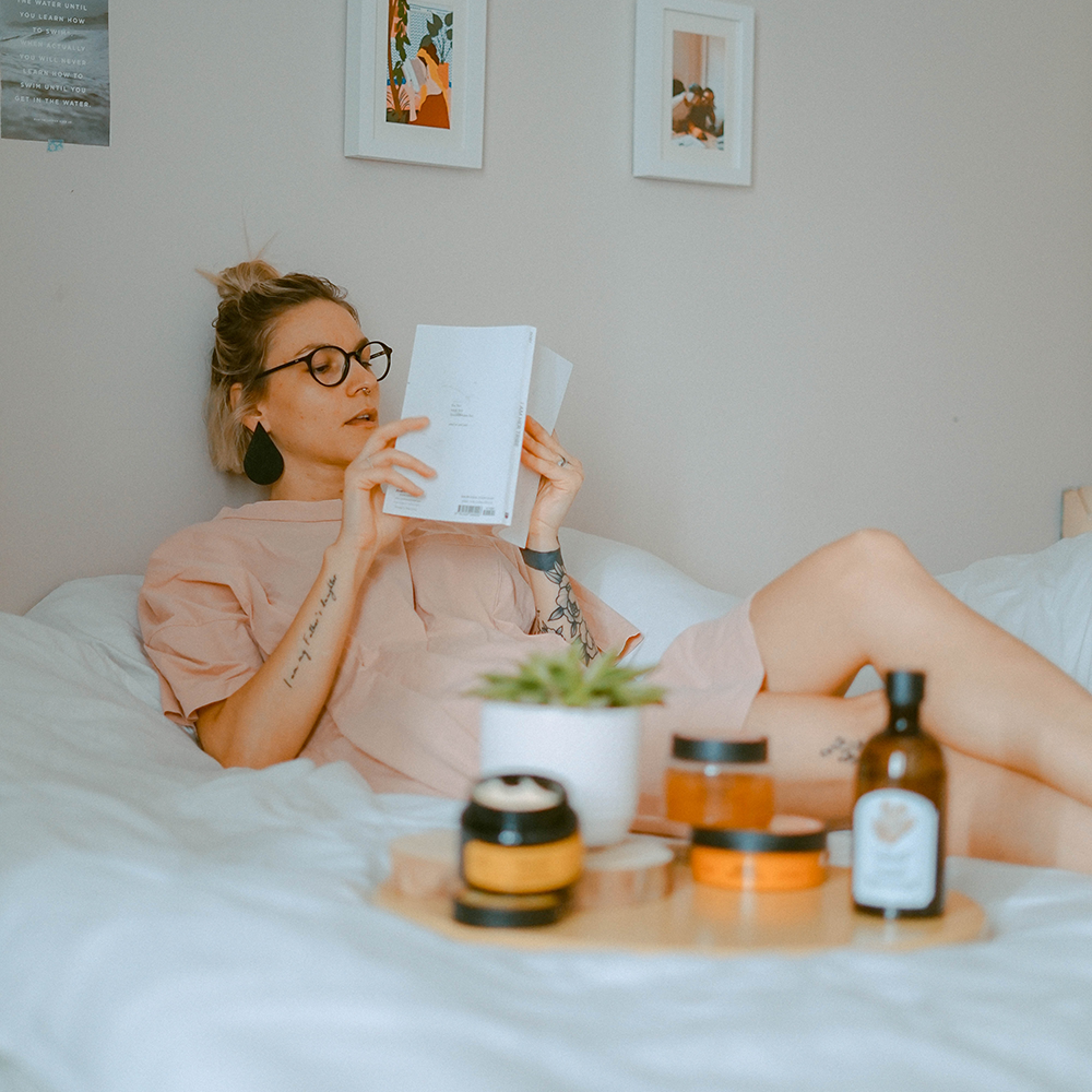 Frau liegt im Bett und liest gemütlich etwas