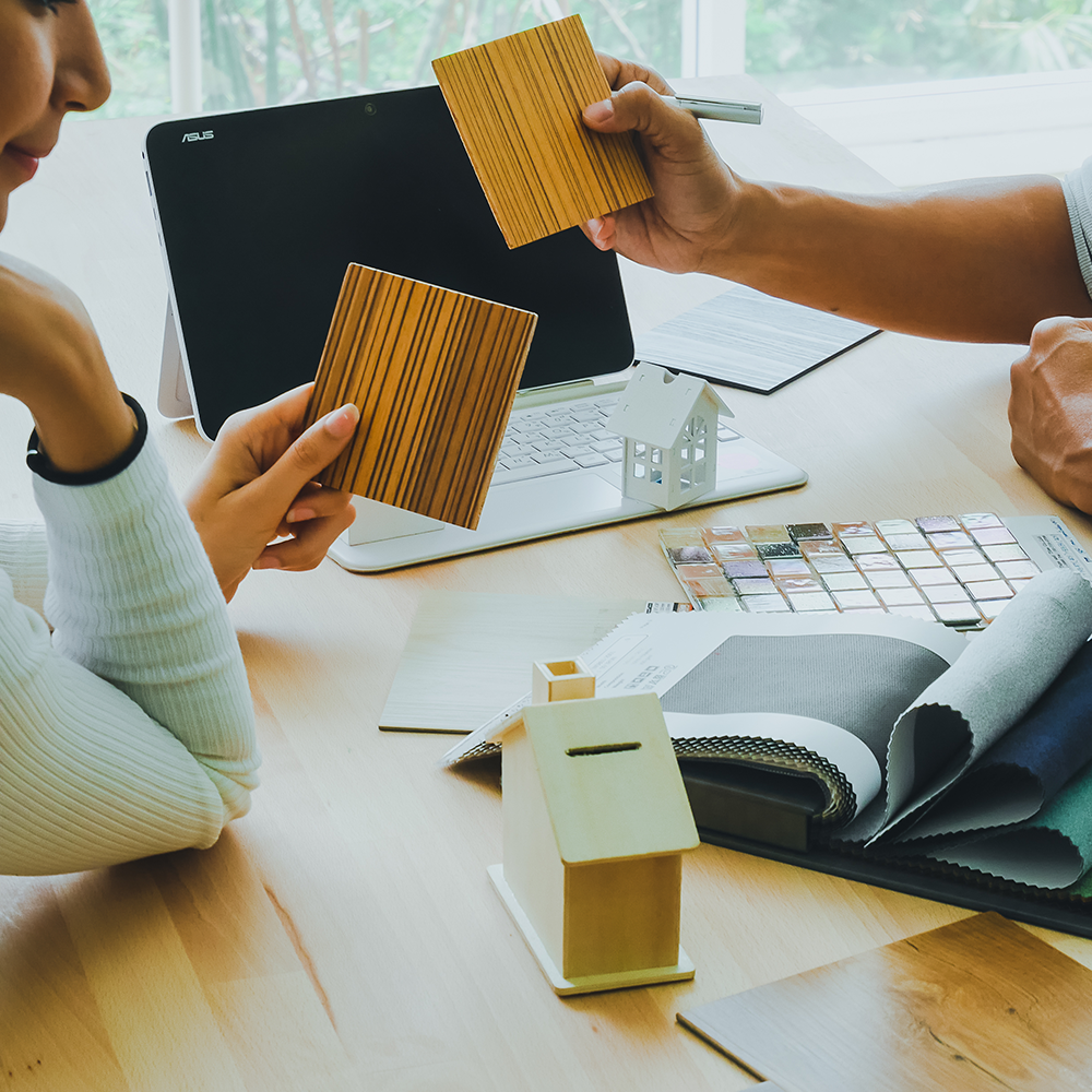 Mann und Frau sitzen am Tisch und diskutieren über mögliche Kombinationen von Interior