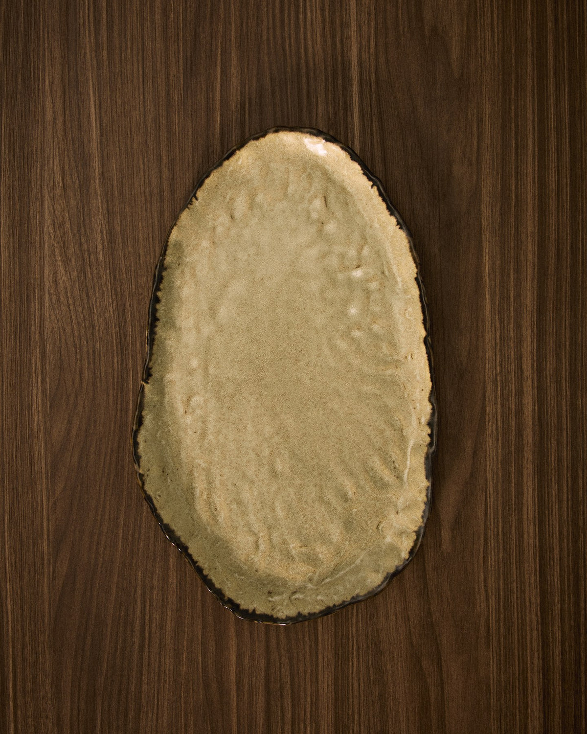 Braunes Keramiktablett Abela mit leicht gewelltem Rand und glasierter Oberfläche, organische unregelmässige Form, Grösse 40 x 24.5 x 2.5 cm.