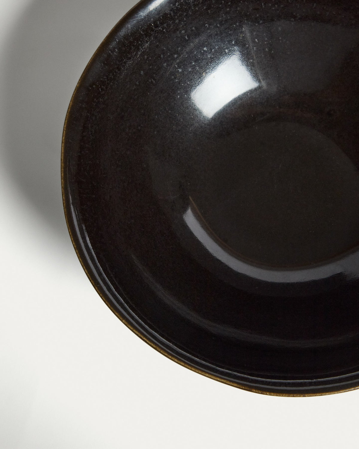 Tiefer Teller aus dunkelbrauner Keramik mit glänzender Oberfläche und runder Form, Durchmesser 27 cm, Höhe 9.5 cm.