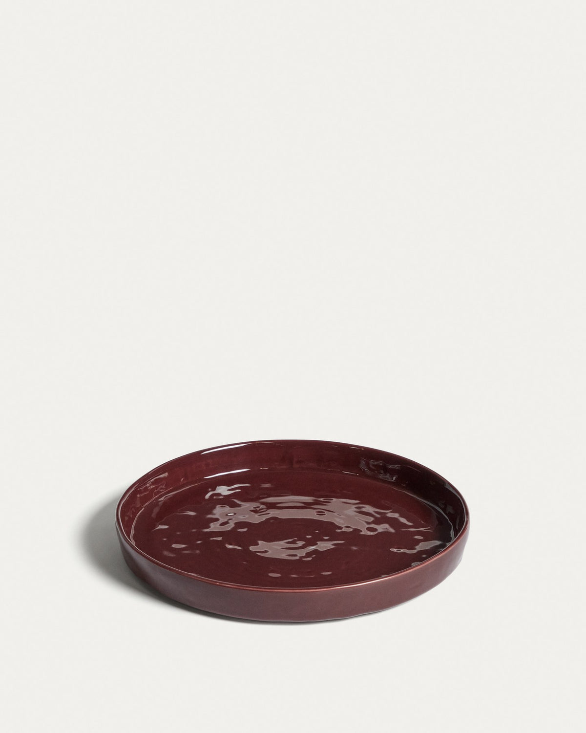 Runder Dessertteller aus glänzender Keramik in burgunderroter Farbe mit leicht variierender Glasuroberfläche, Kave Home Kollektion Daner.