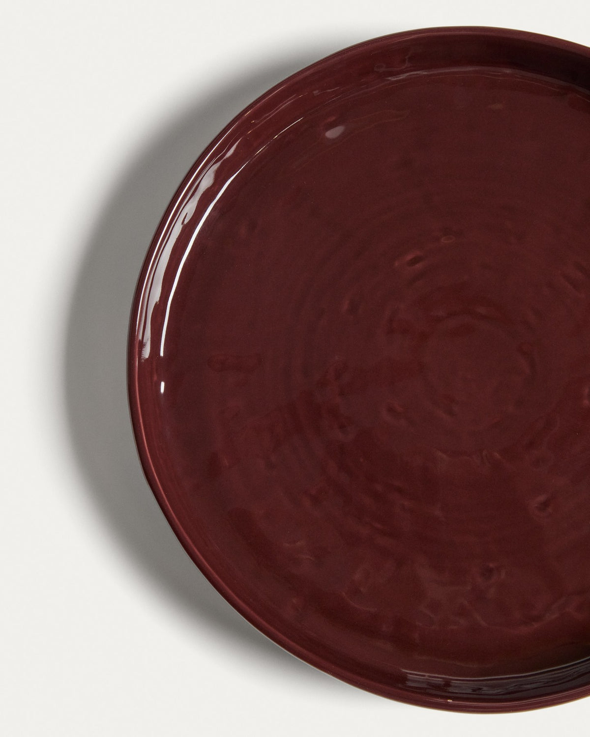Runder Dessertteller aus glänzender Keramik in burgunderroter Farbe mit leicht variierender Glasuroberfläche, Kave Home Kollektion Daner.