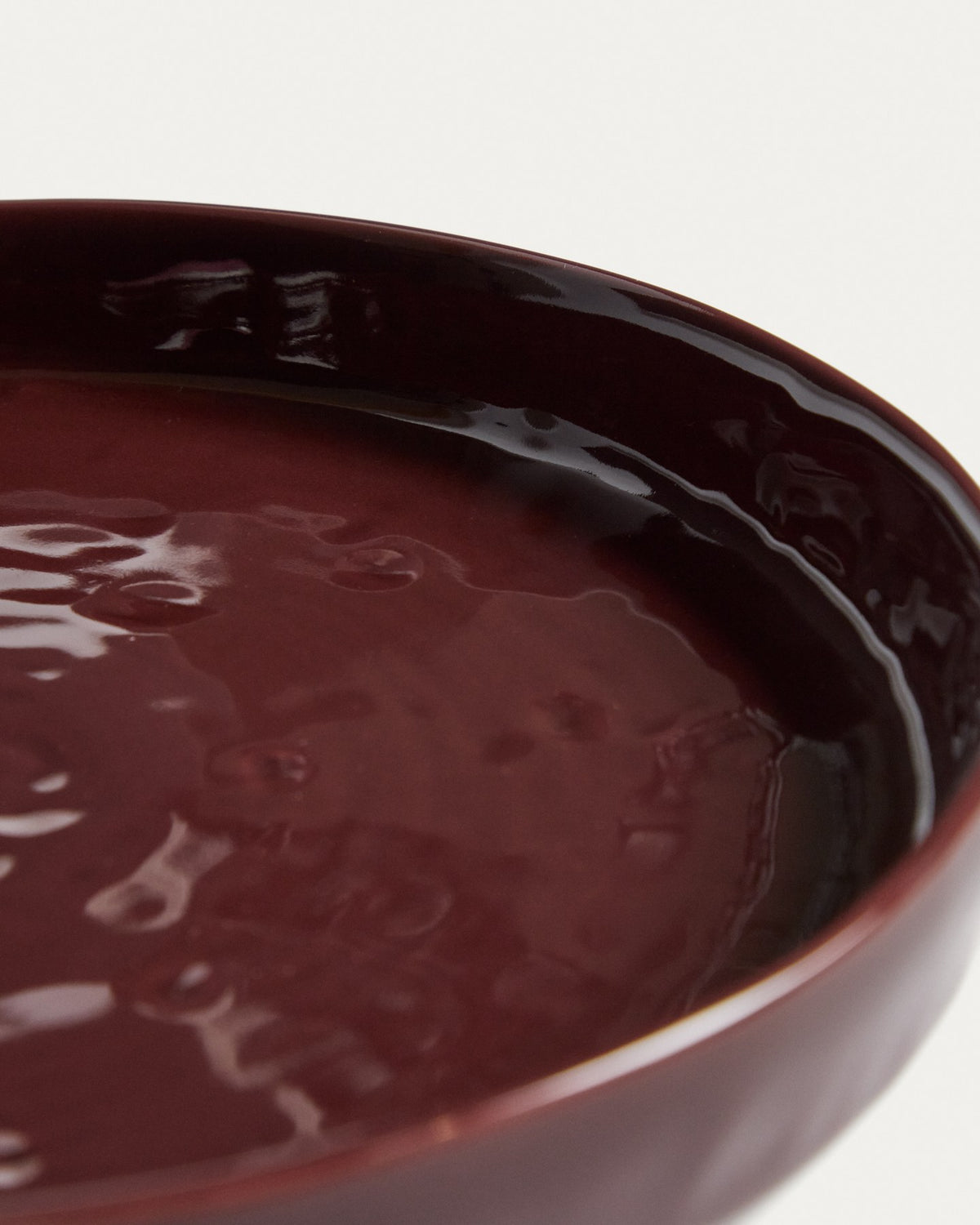 Runder Dessertteller aus glänzender Keramik in burgunderroter Farbe mit leicht variierender Glasuroberfläche, Kave Home Kollektion Daner.