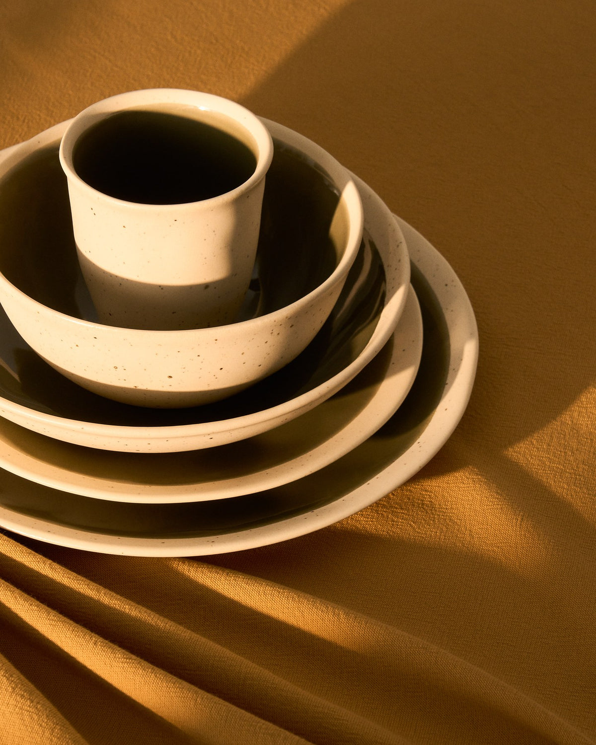 Flacher Keramikteller Nale von Kave Home in Beige mit grünem Boden, glänzende Oberfläche, runde Form, Durchmesser 23 cm.