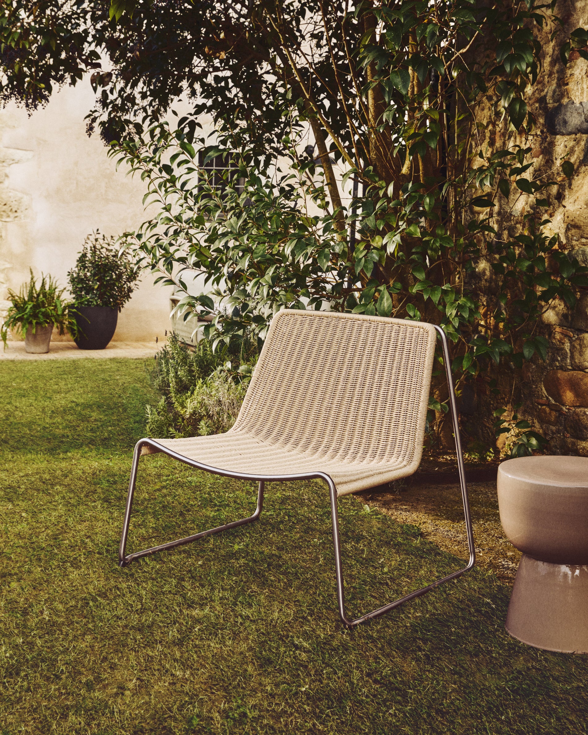 Bequemer Stapelsessel Tavari in elegantem Beige, gefertigt aus robustem Synthetikseil und gebürstetem Edelstahl, ideal für den Außenbereich.
