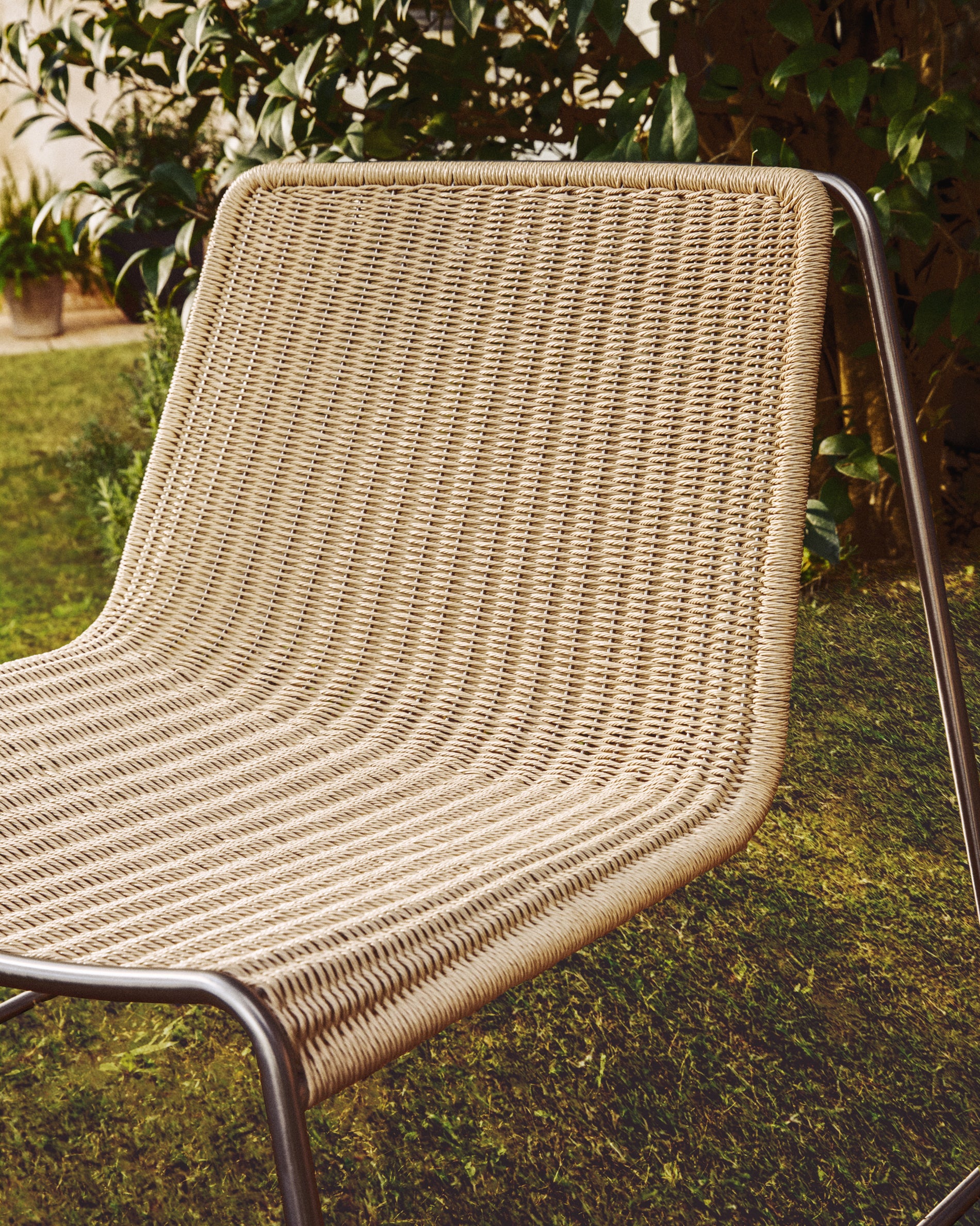 Stylischer Stapelsessel Tavari in sanftem Beige, aus langlebigem Synthetikseil und gebürstetem Edelstahl, perfekt für Garten und Terrasse.
