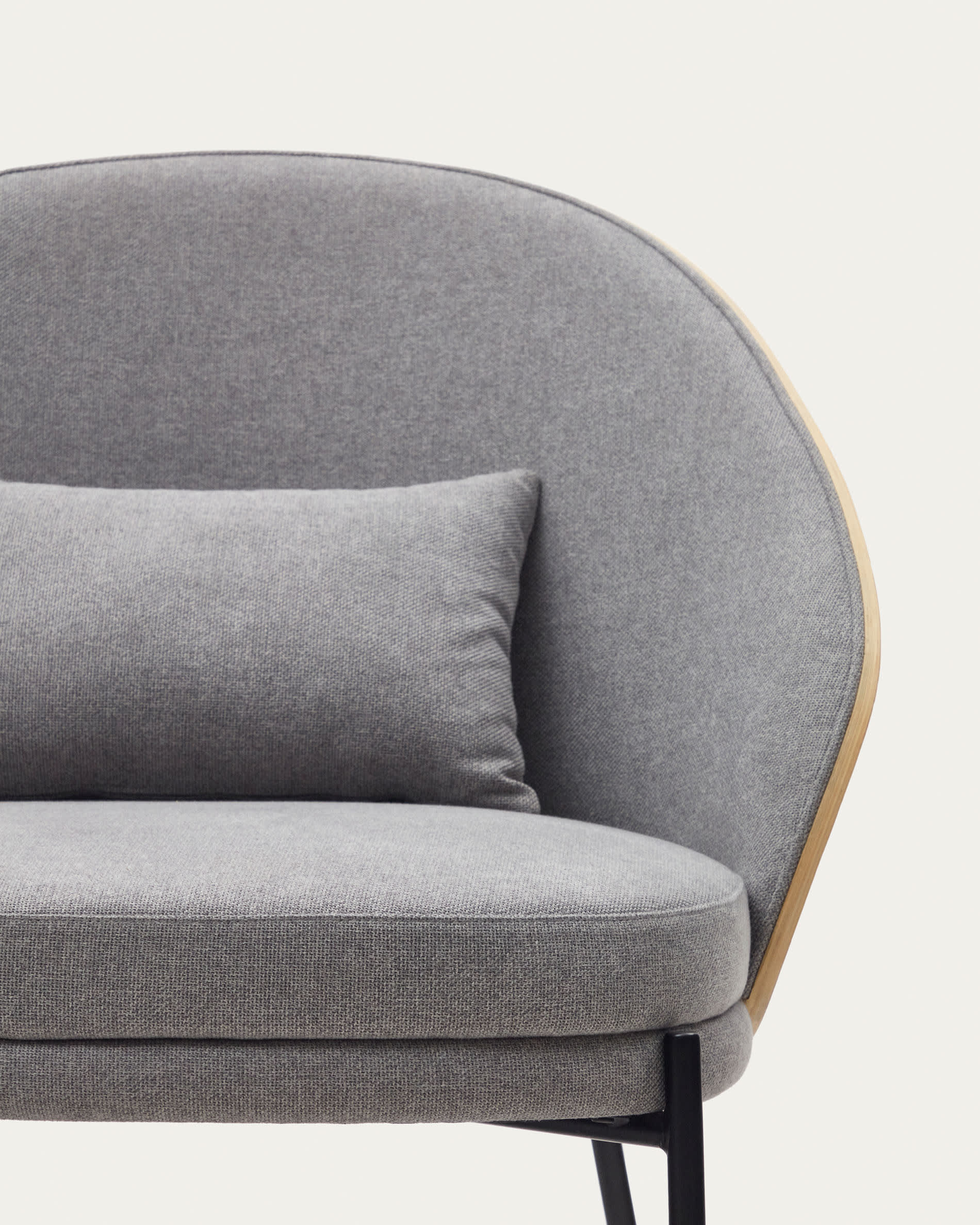 Moderner Eamy Sessel in sanftem Hellgrau, kombiniert mit robustem Eschenfurnier und eleganten schwarzen Metallbeinen – perfekt für Ihr Zuhause.