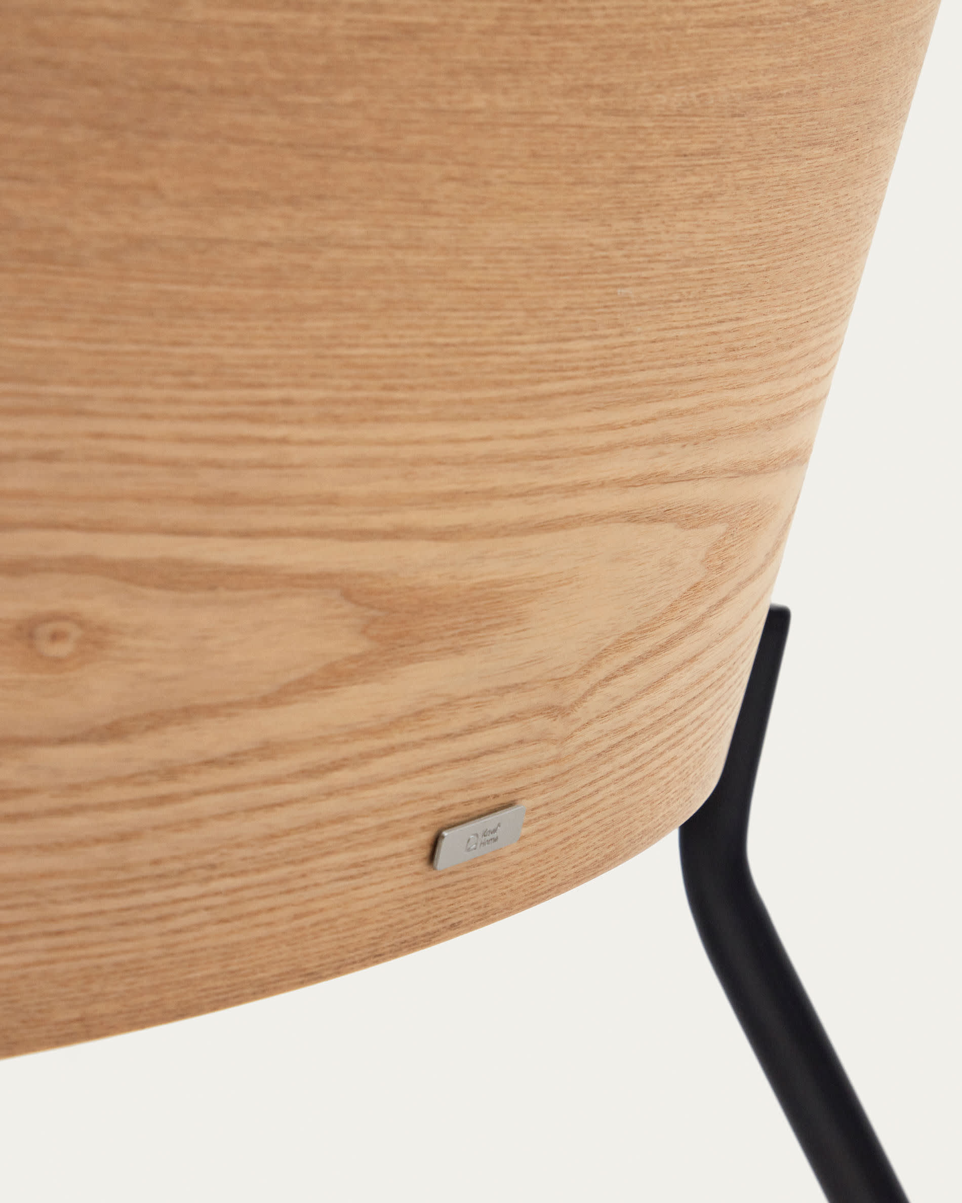 Moderner Eamy Sessel in sanftem Hellgrau, kombiniert mit robustem Eschenfurnier und eleganten schwarzen Metallbeinen – perfekt für stilvolle Interiors.