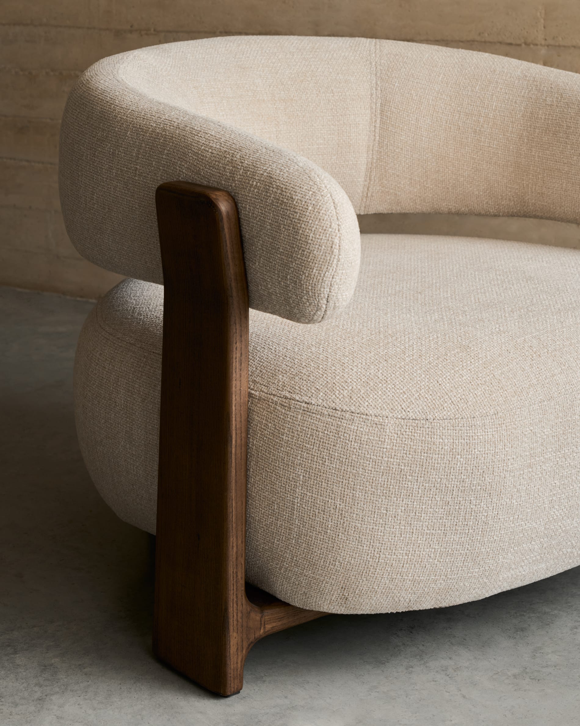 Moderner Sessel aus beiger Chenille, FSC-zertifizierte Eschenholzbeine mit Walnuss-Finish, stilvoll und umweltfreundlich.