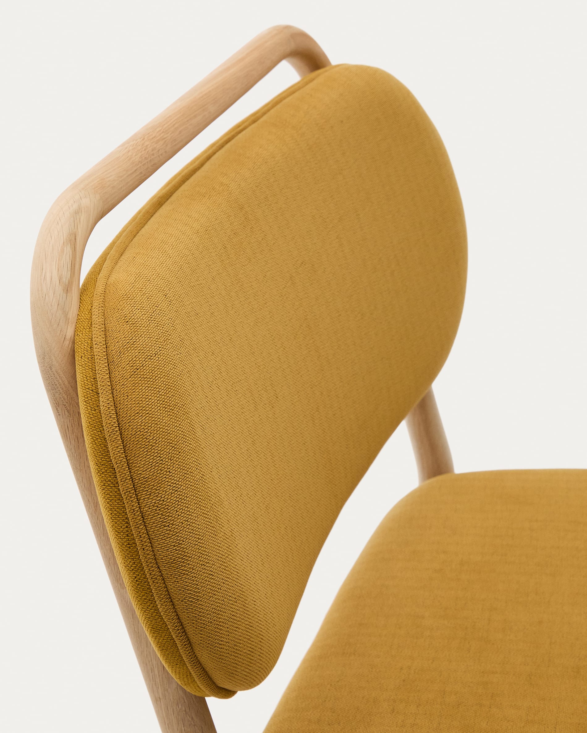 Der Sessel Helda kombiniert luxuriösen senfgelben Chenille mit robustem Eichenholz und bringt zeitlose Eleganz in Ihr Zuhause.