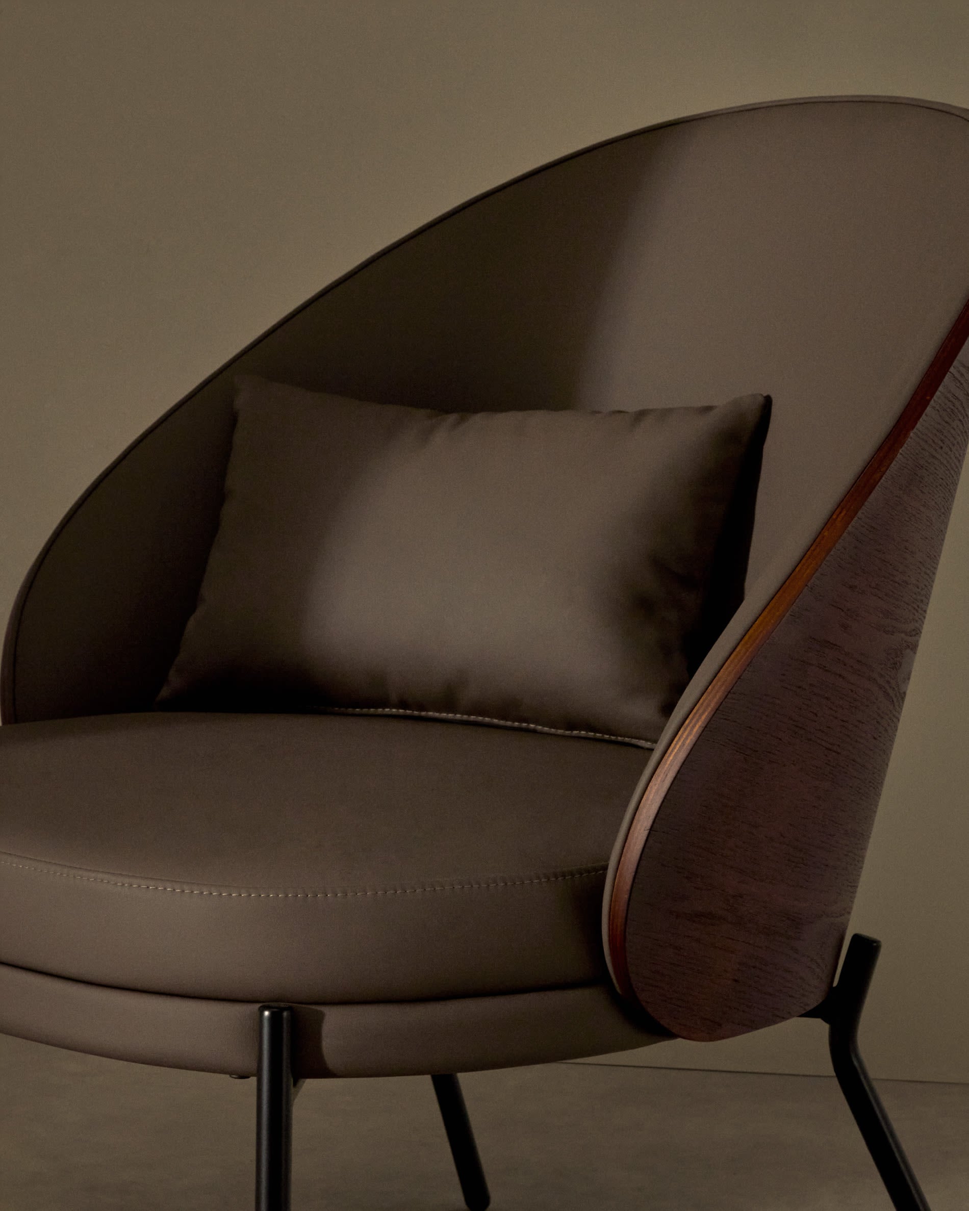 Eleganter Eamy Sessel: braunes Kunstleder, Nussbaum-Eschenfurnier, schwarzes Metallgestell – stilvoll und komfortabel.