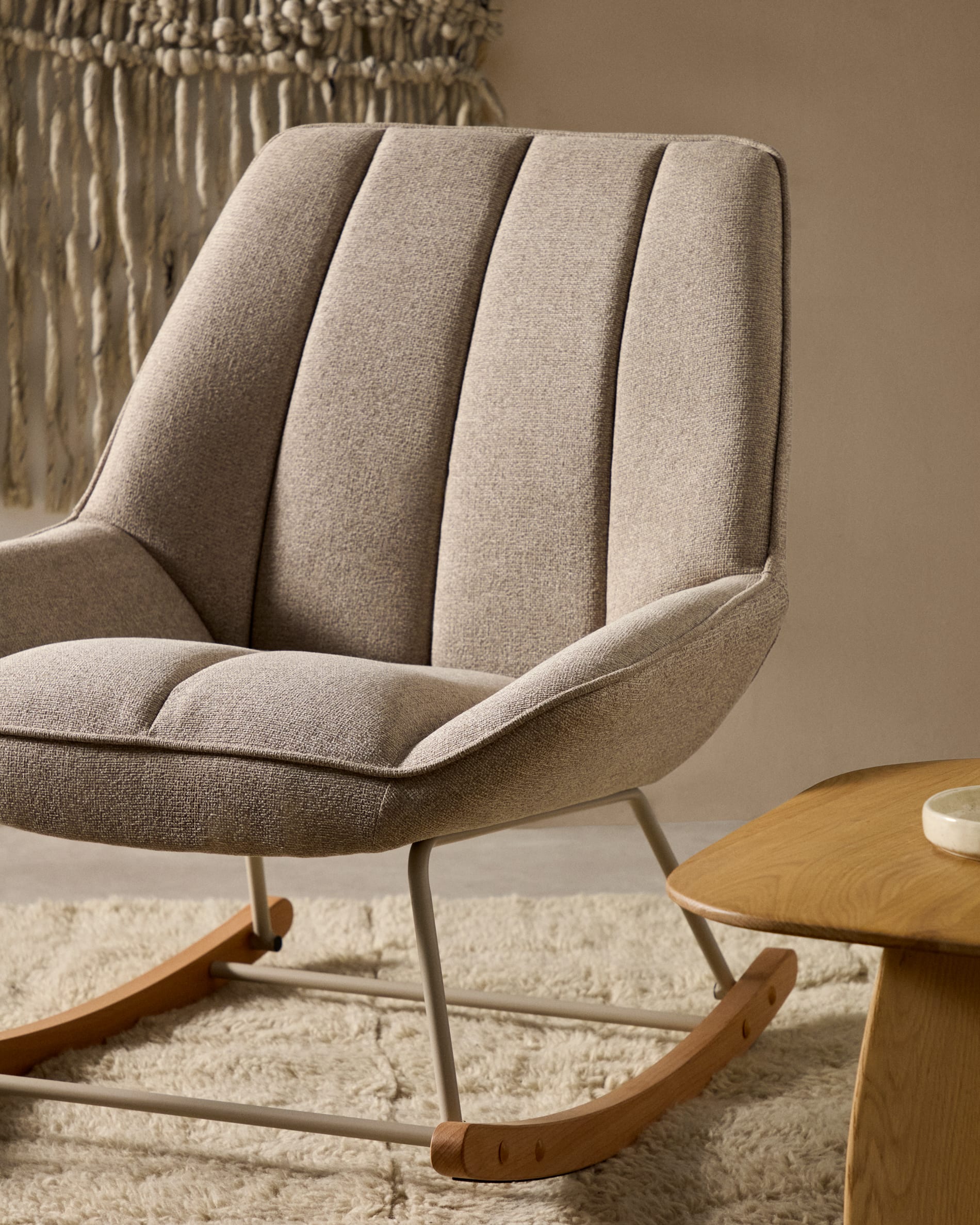 Moderner Schaukelstuhl Marlina mit beigem Chenille-Stoff und grauem Metallgestell, ideal für stilvolle Entspannung.