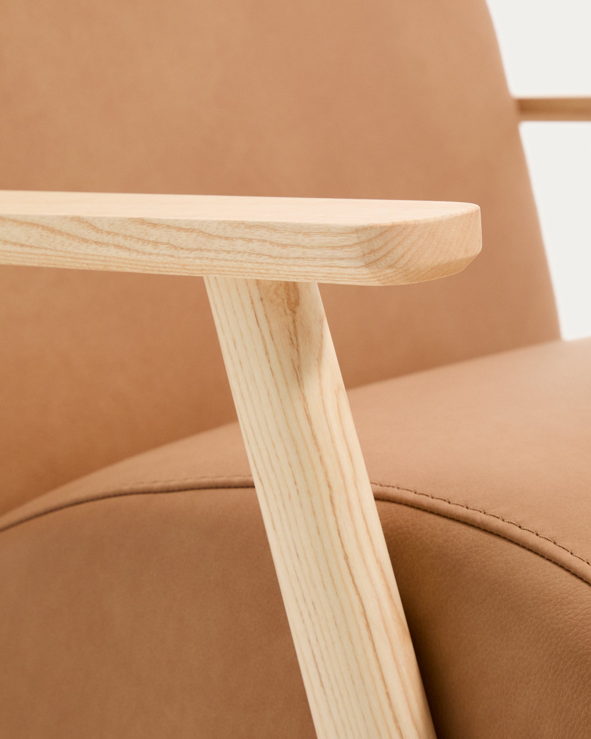 Stilvoller Sessel Meghan in braunem Leder, kombiniert mit massivem Eschenholz in Naturfarbe, perfekt für gemütliche Wohnambiente.