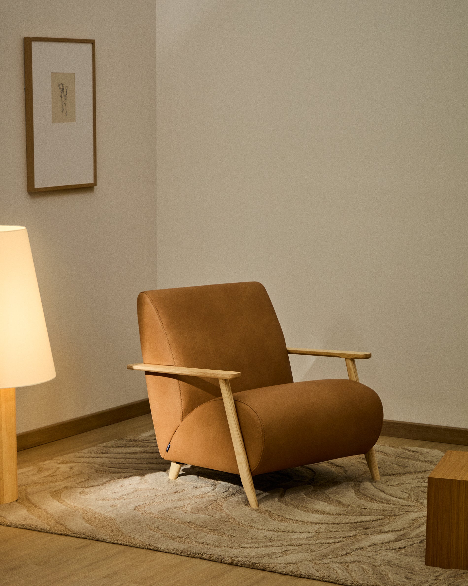 Eleganter Sessel Meghan aus braunem Leder und robustem Eschenholz, ideal für stilvolle Wohnräume, präsentiert von Kave Home.