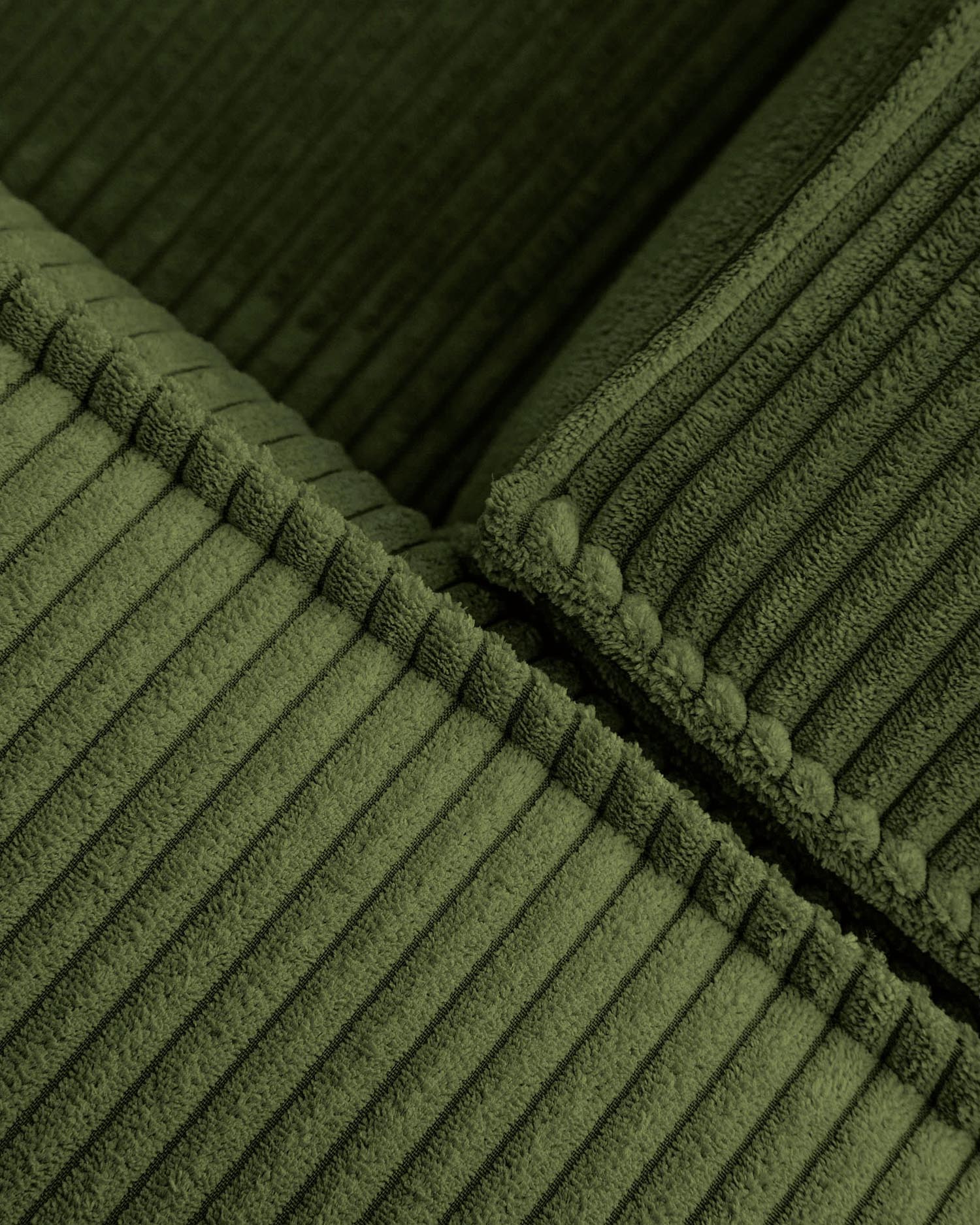 Erleben Sie das Blok 5-Sitzer-Ecksofa in luxuriösem, grünem Cord. Ideal für gesellige Abende, bietet es stilvollen Komfort und Flexibilität.