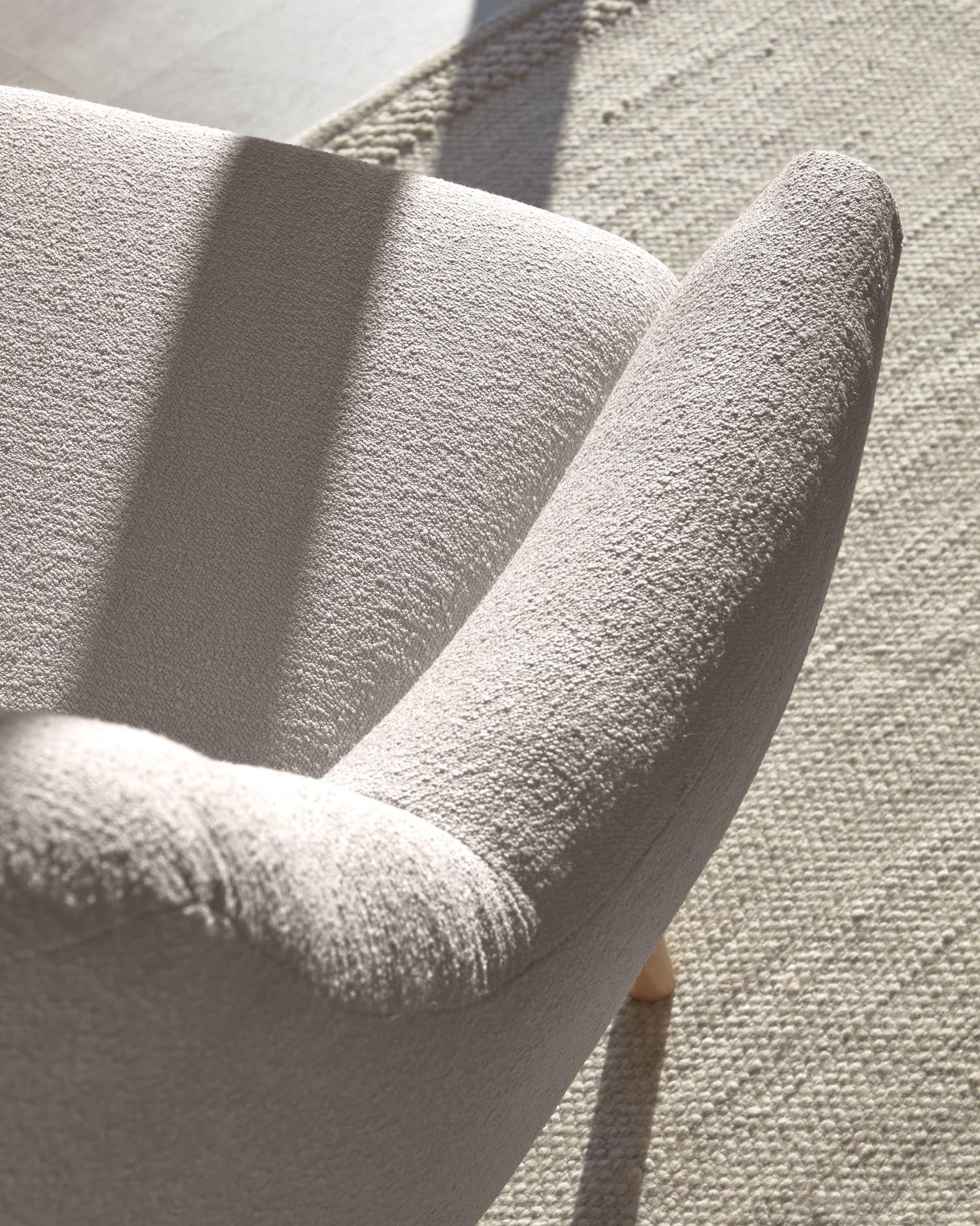 Eleganter Candela Sessel in Grau aus weichem Mikro-Bouclé. Ideal für gemütliche Wohnräume, vereint Komfort und nachhaltige Materialien.