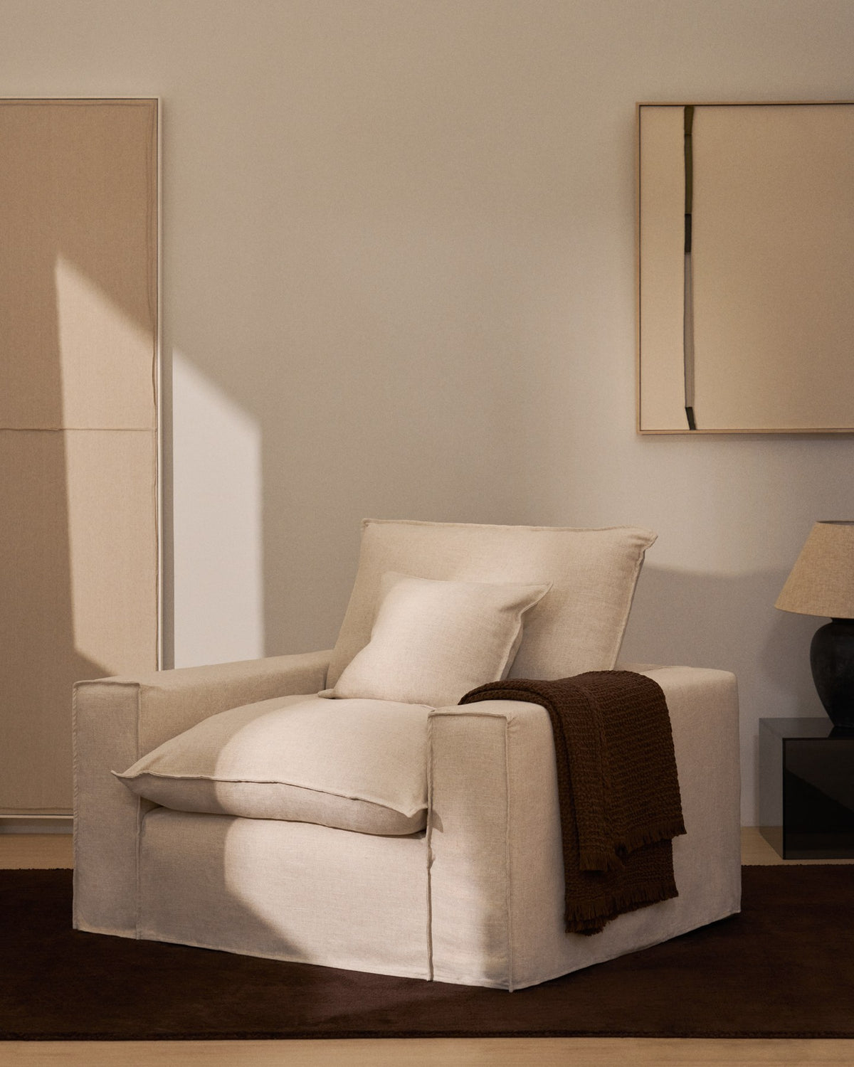 Sessel Anarela in Beige mit abnehmbarem Bezug aus Leinen und Viskose, schwarze Beine aus Polypropylen, Breite 130 cm.