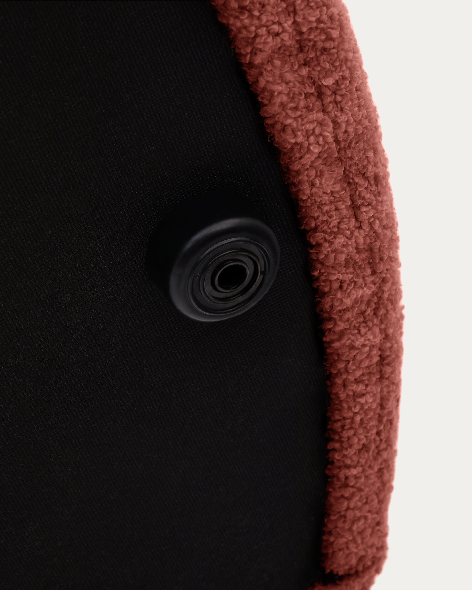 Eleganter Fusshocker Kaeli in terrakottafarbenem Bouclé, Ø 60 cm. Vielseitig einsetzbar, abnehmbarer Bezug für einfache Pflege und nachhaltiges Design.