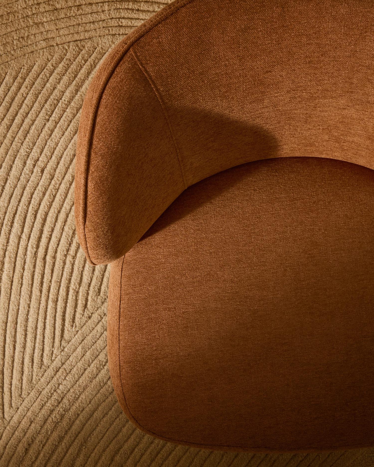 Eleganter Sessel Ulit in terrakottafarbener Chenille, mit robusten Beinen aus massivem Buchenholz im natürlichen Finish, modern und bequem.